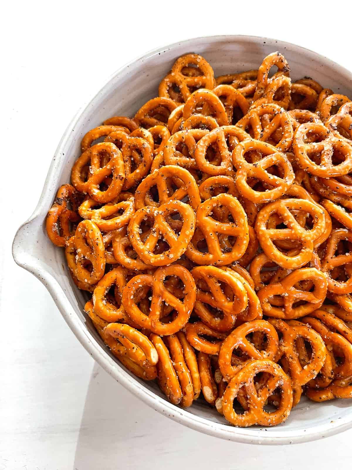a white bowl filled with spicy seasoned pretzels