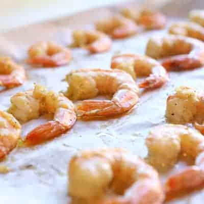 shrimp lined up on a baking sheet