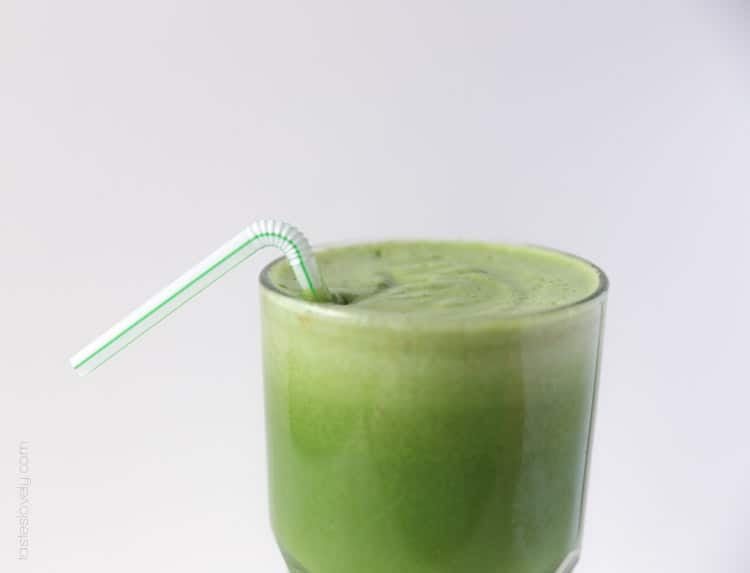 detox green juice after it's been juiced in a tall glass with a straw