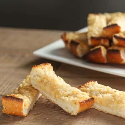 slices of homemade garlic bread on a table next to a white plate