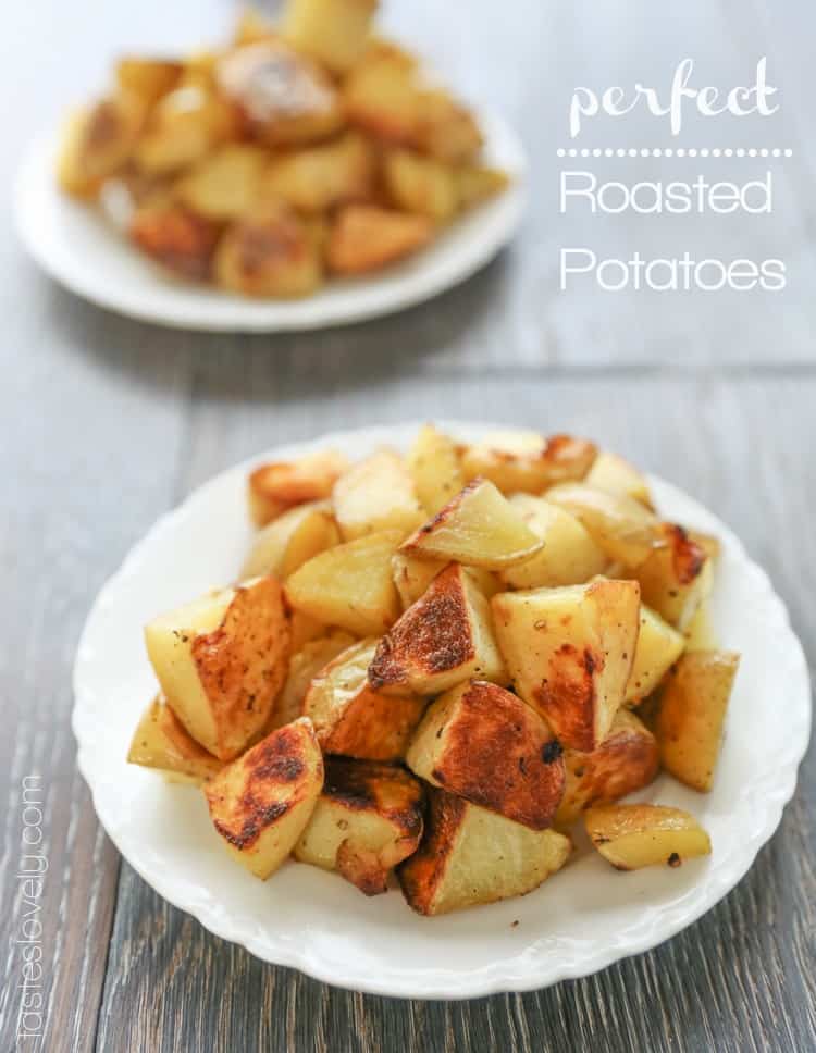 two white plates topped with roasted golden potatoes 