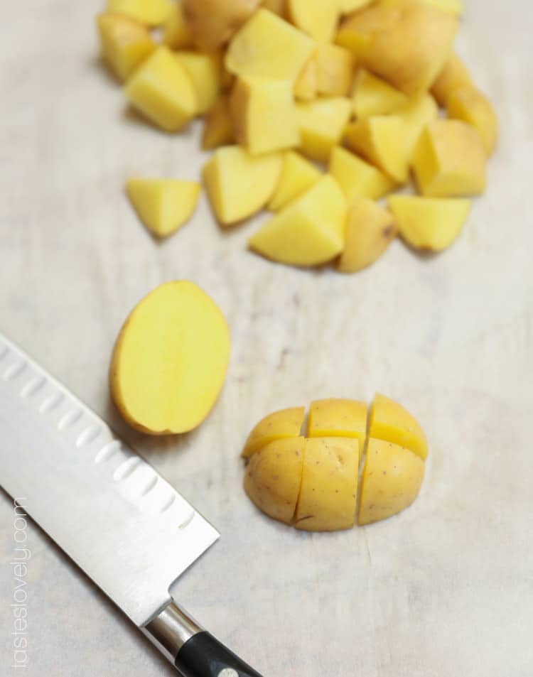 a Yukon gold potato getting sliced into 1 inch cubes