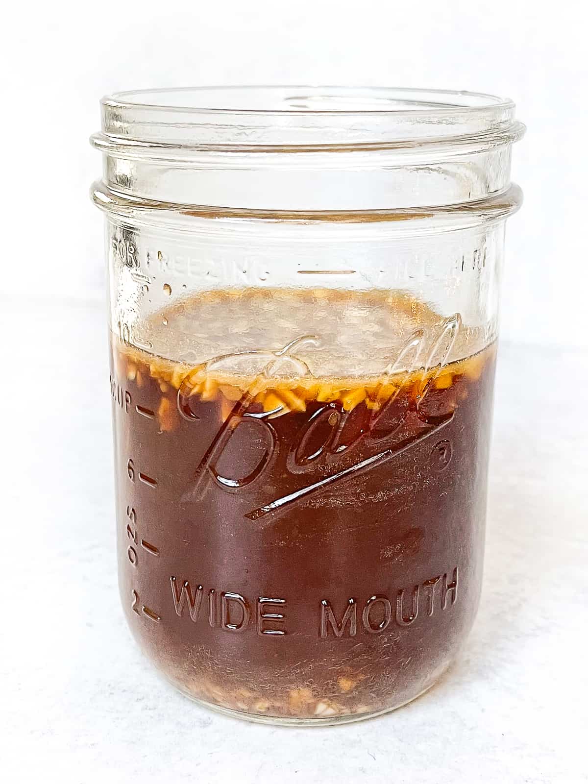 a mason jar filled with the best sauce to pour over stir fried meat and veggies