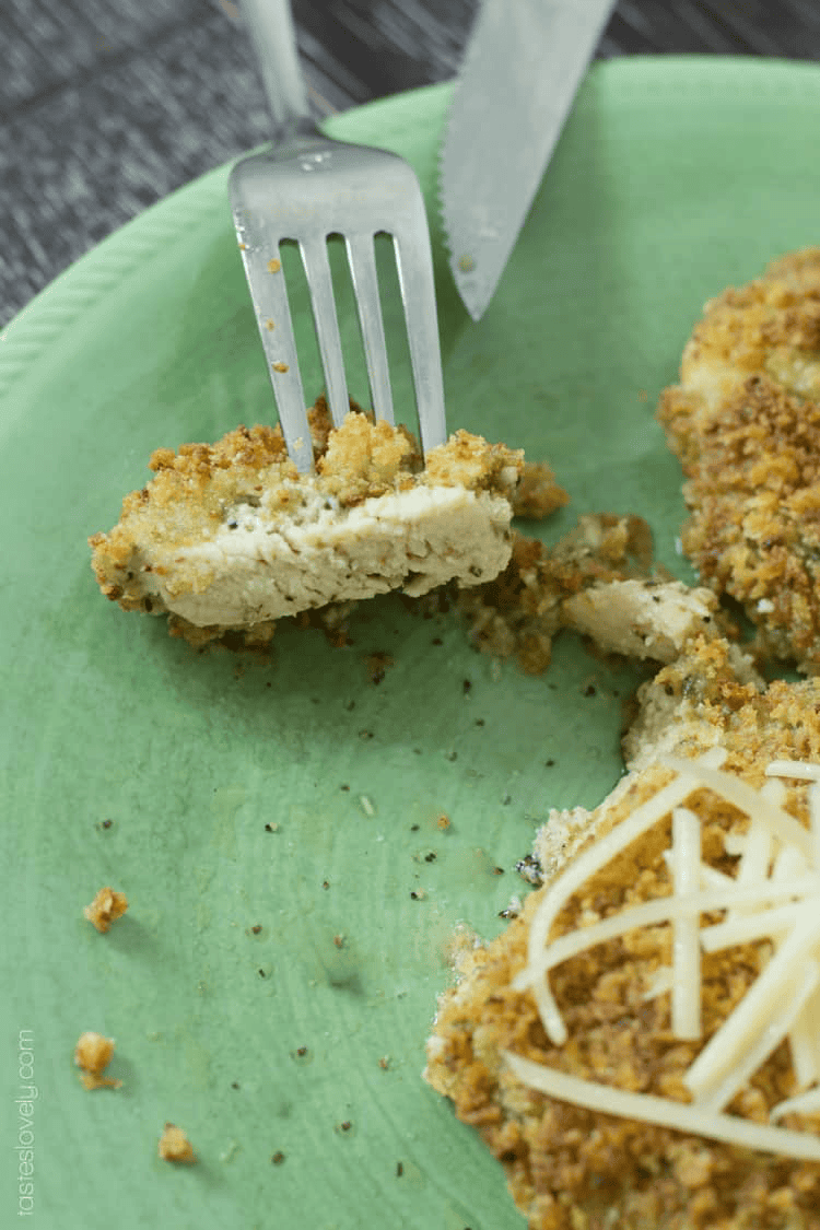 bites of chicken parmesan on a green plate with a fork and knife