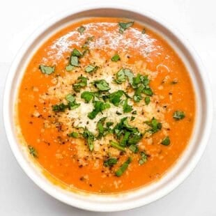 an overhead shot of a white bowl filled with tomato soup