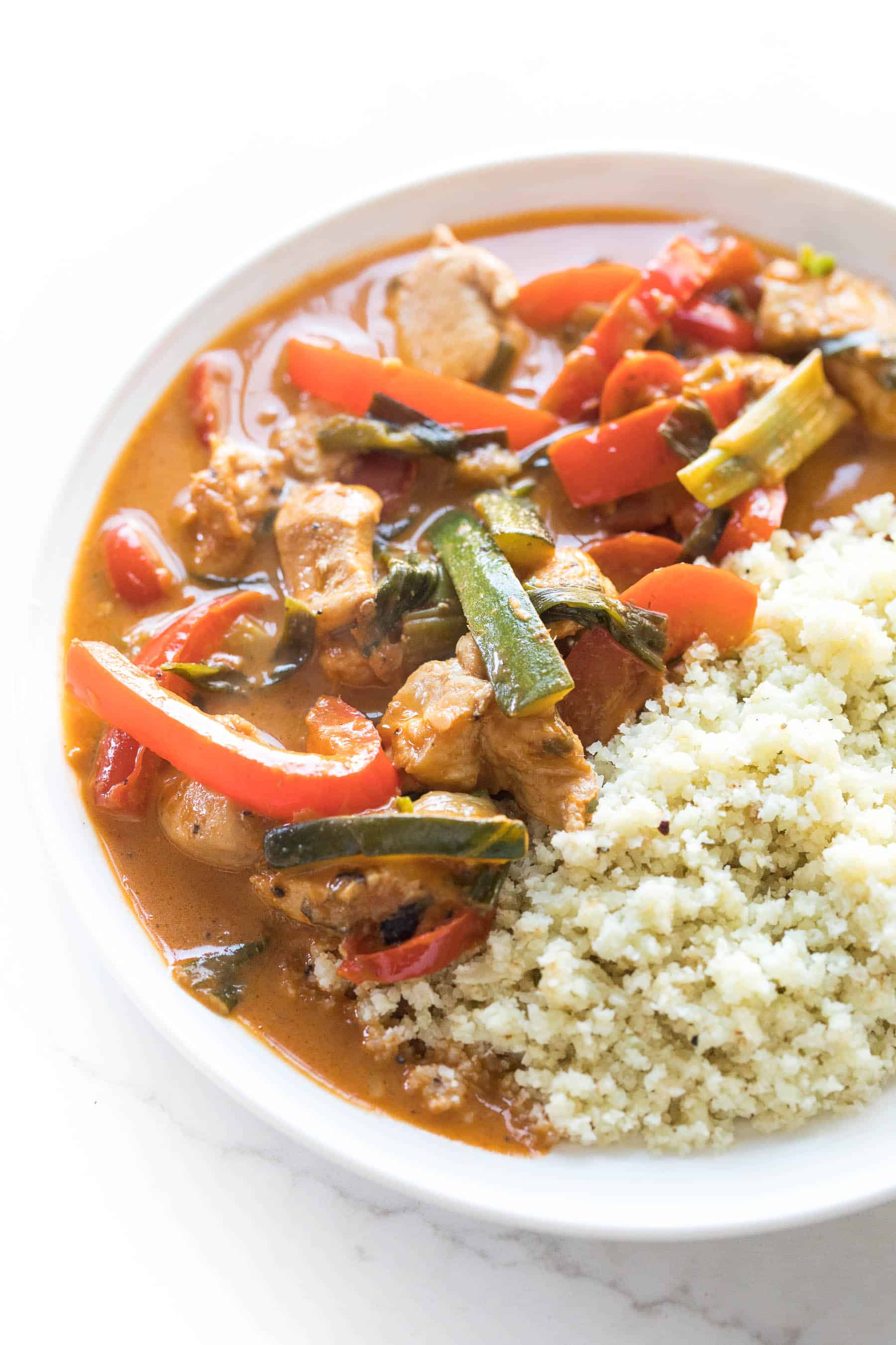 coconut chicken thai curry on a white plate with cauliflower rice