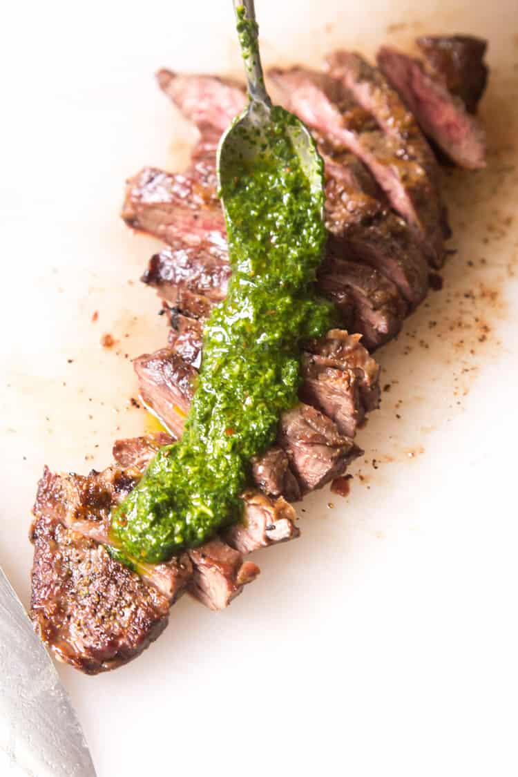 Skirt steak with chimichurri sauce - a delicious (and affordable!) steak dinner topped with a cilantro parsley mixture. #paleo #whole30 #glutenfree #lowcarb