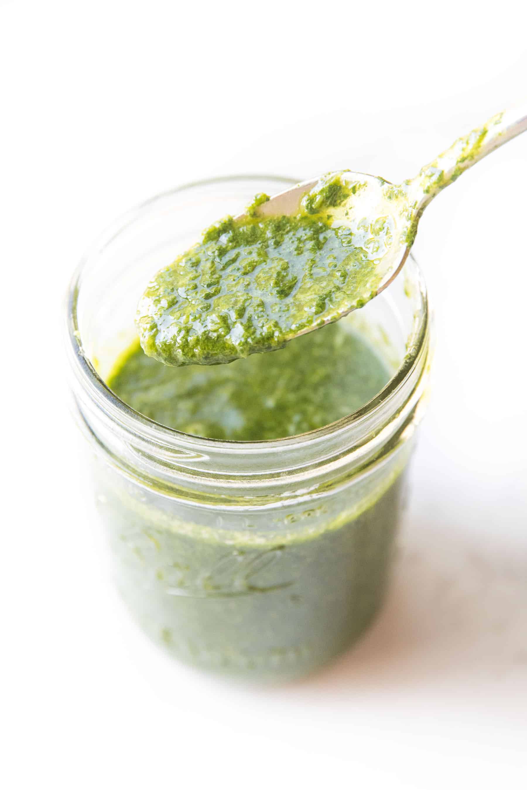 Spoon pouring chimichurri sauce in a mason jar