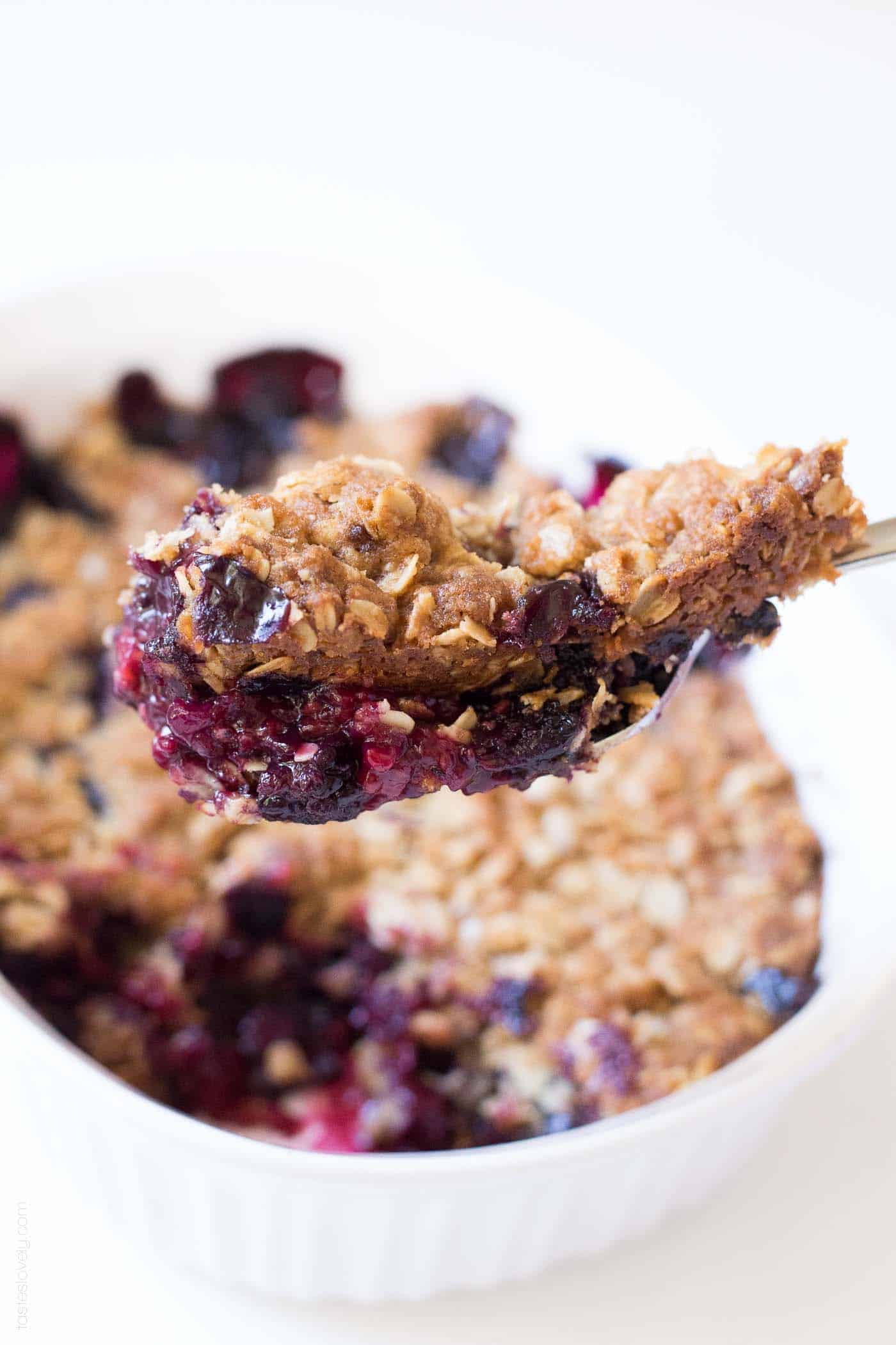 closeup of a bite of berry crumble with oat crumble topping