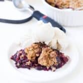 frozen berry crumble topped with oat crumble topping and vanilla ice cream