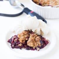 frozen berry crumble topped with oat crumble topping and vanilla ice cream