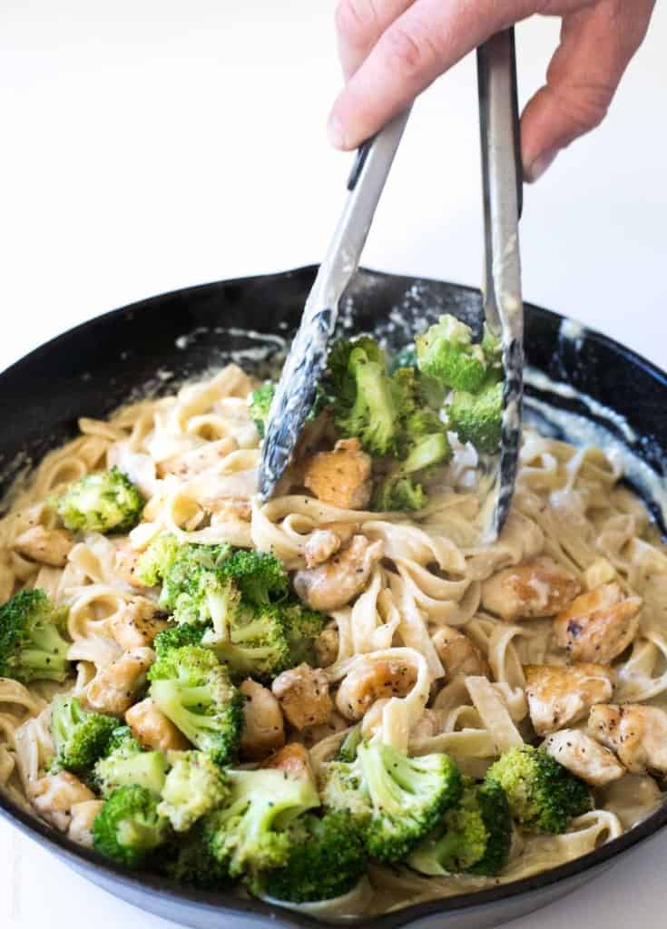 Stirring homemade broccoli chicken fettucine alfredo
