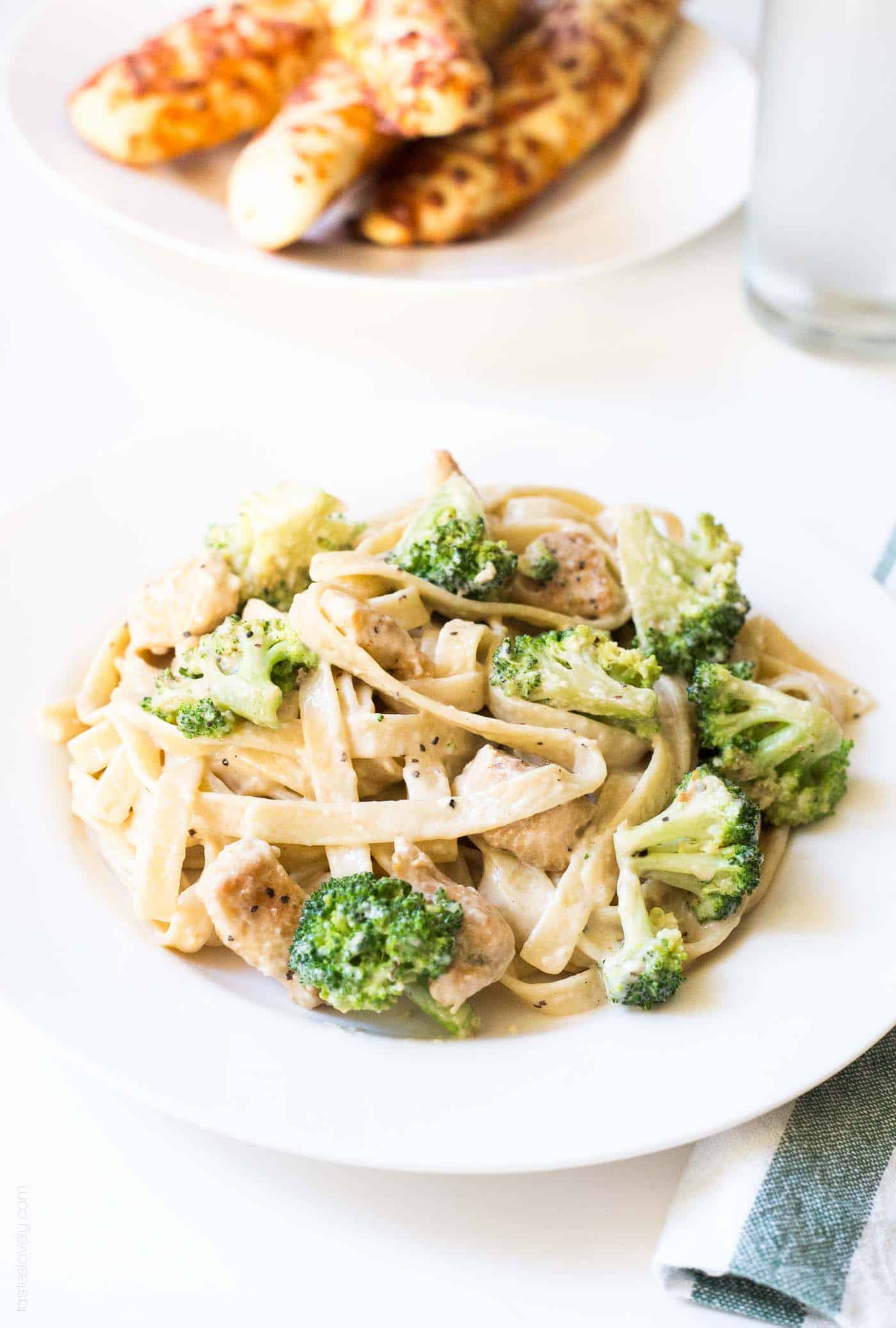 Broccoli chicken fettucine alfredo on a white plate