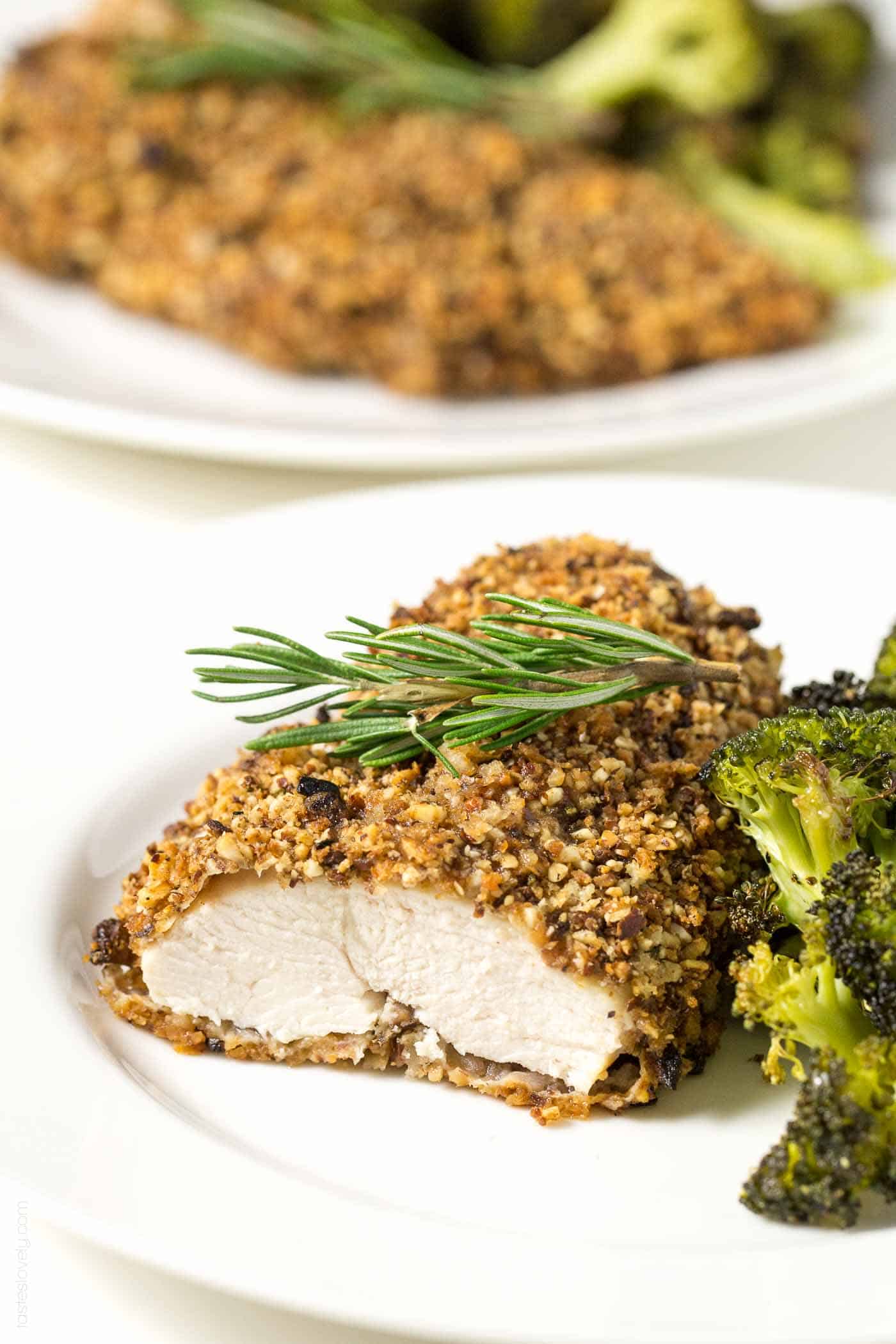 a piece of Almond Crusted Chicken on a plate next to roasted broccoli
