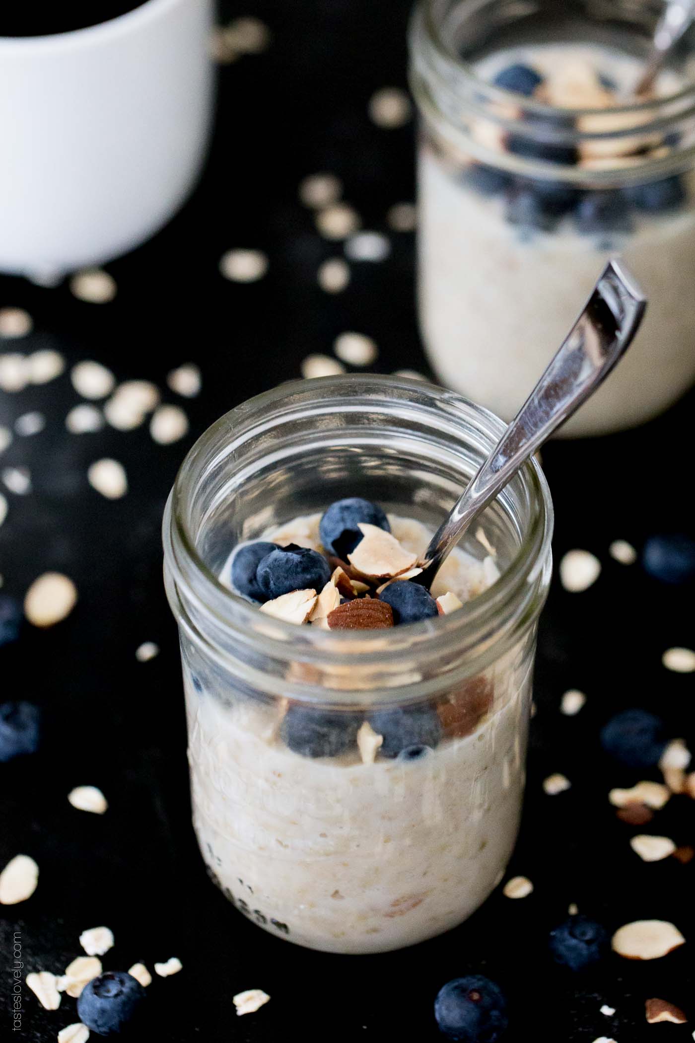 a jar of blueberry overnight oats in a glass mason jar with a silver spoon