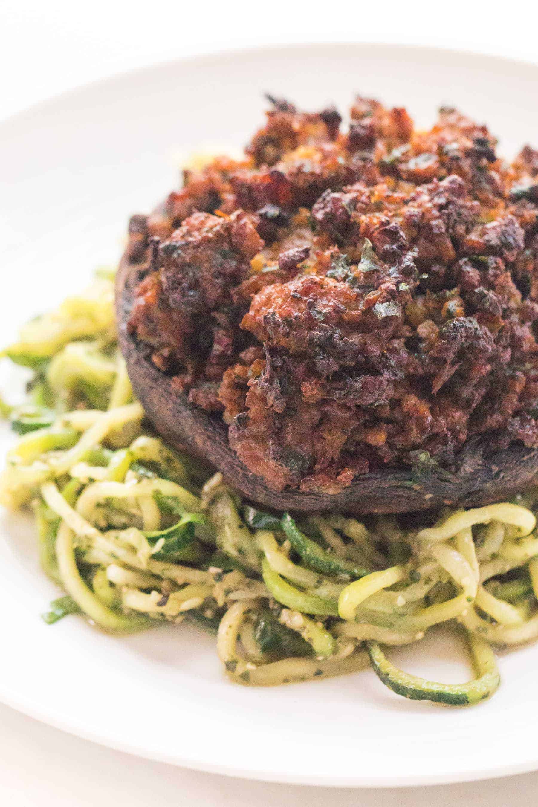 a closeup of keto stuffed mushrooms over zucchini noodles