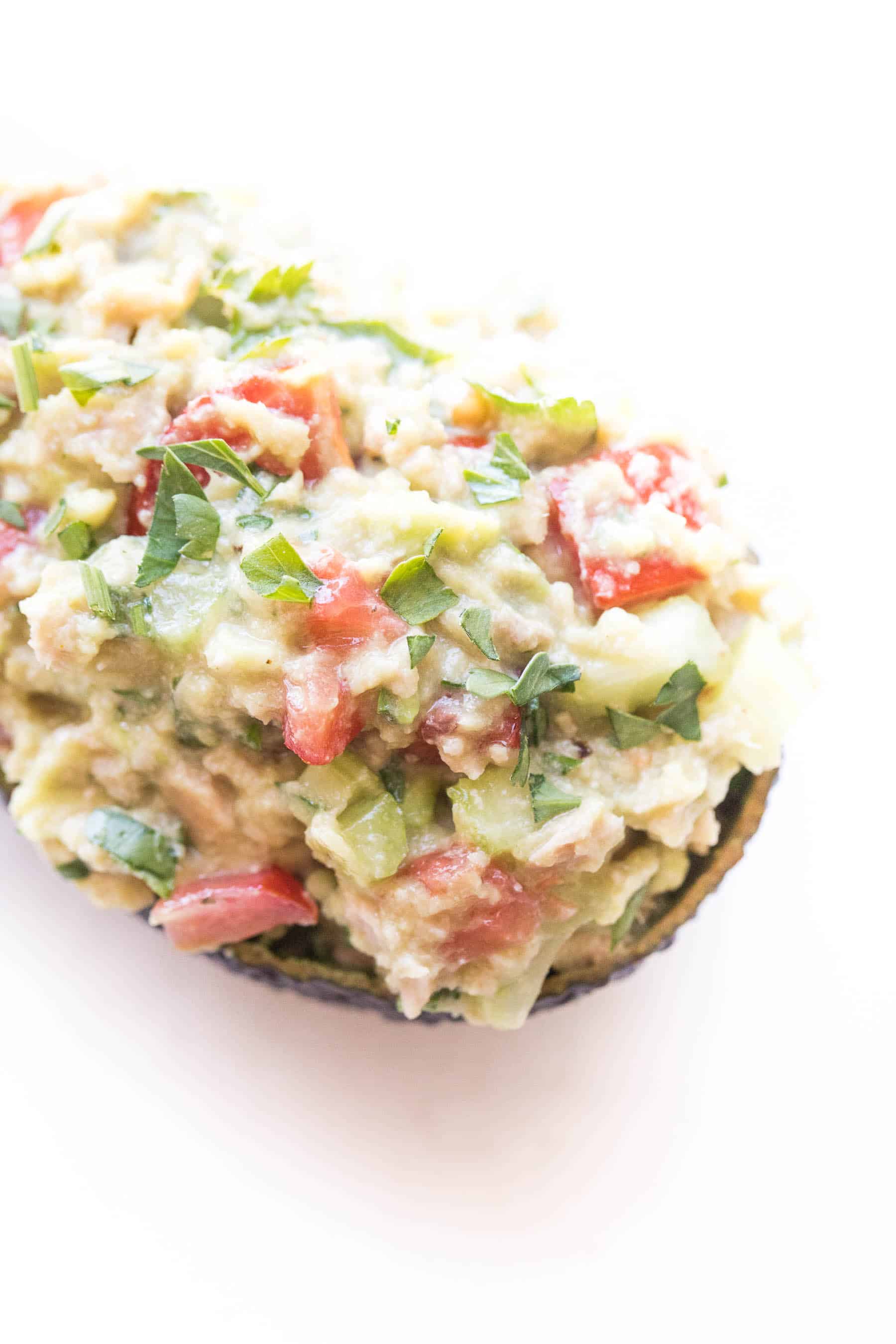 Avocado tuna salad in an avocado boat skin on a white background