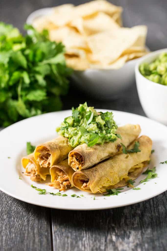 Baked Shredded Chicken Taquitos - juicy Mexican shredded chicken made in the slow cooker, then wrapped in corn tortillas, sprayed with olive oil, and baked in the oven. Great for an appetizer or dinner, and much healthier than fried!