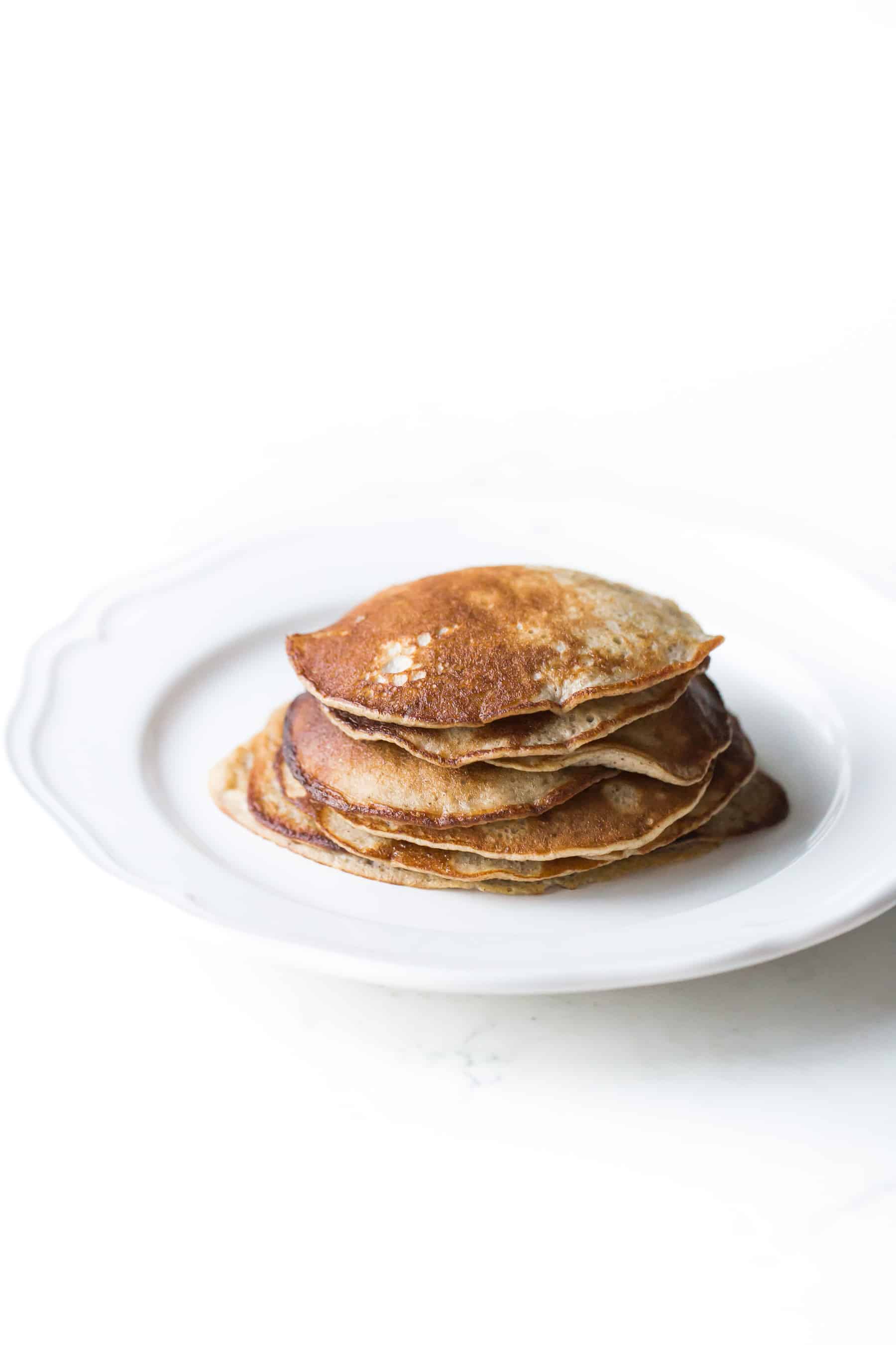 stack of small pancakes on a white plate