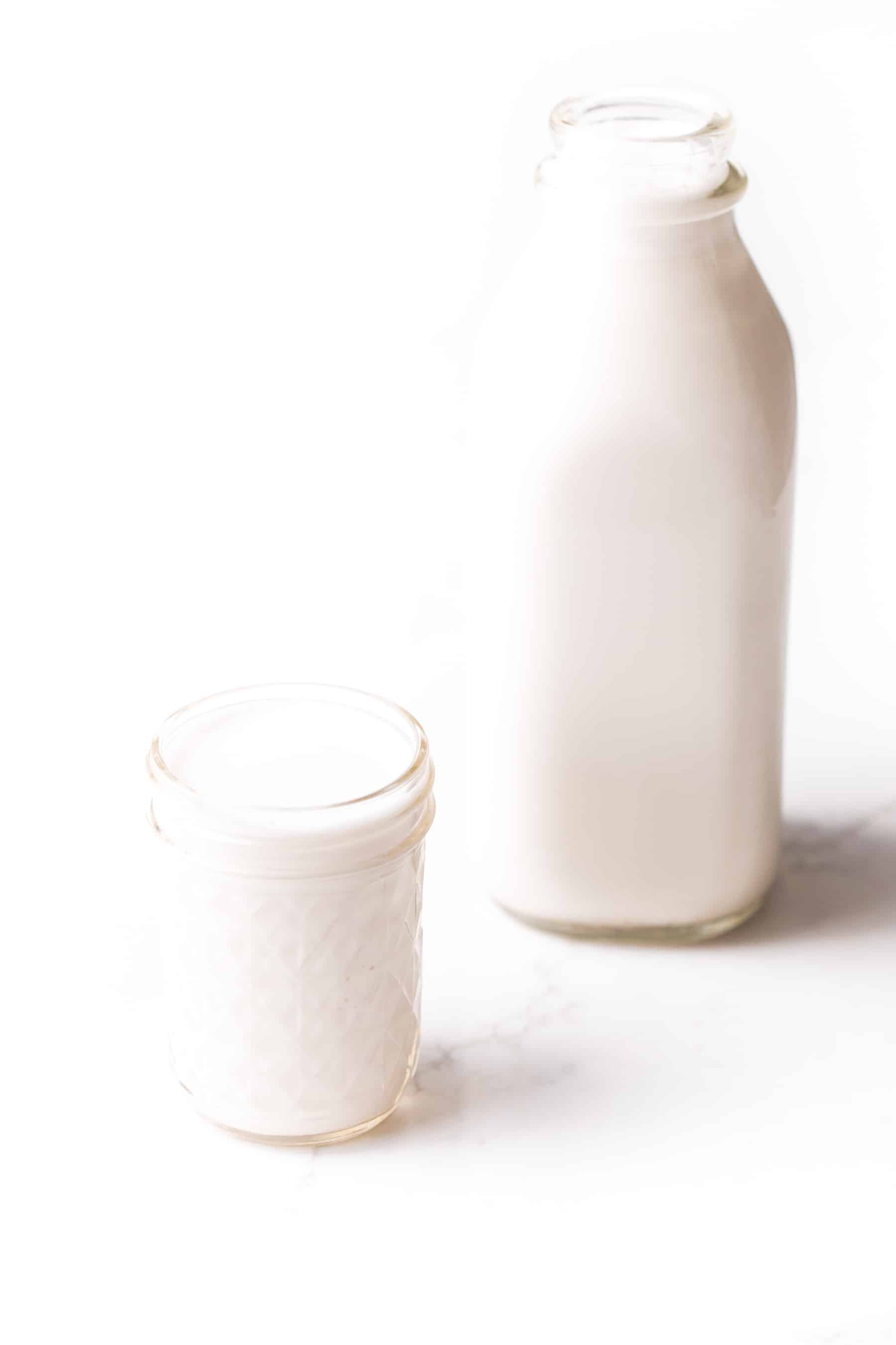 almond milk in a jar and a mason jar cup on a white background