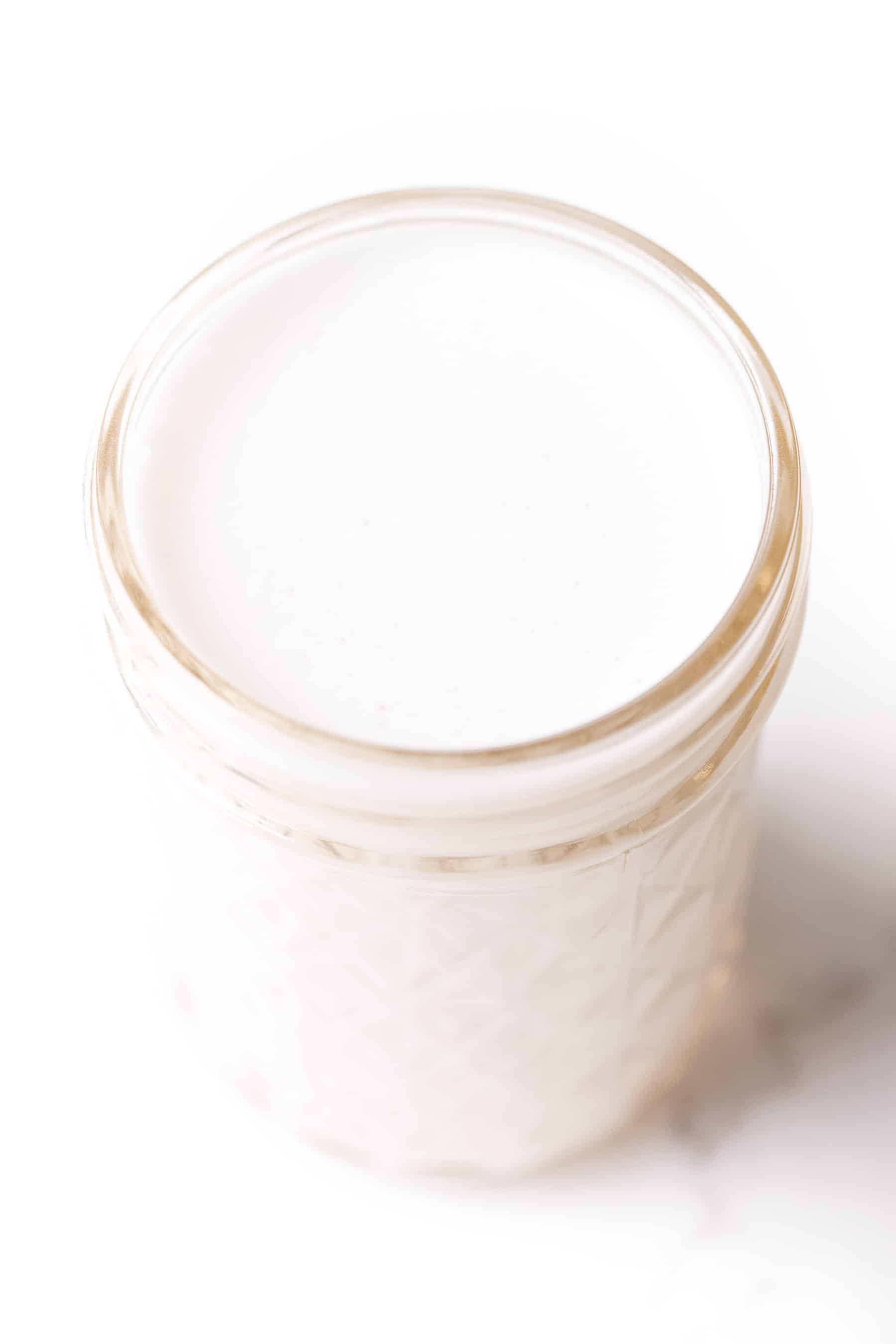 almond milk in a mason jar cup on a white background