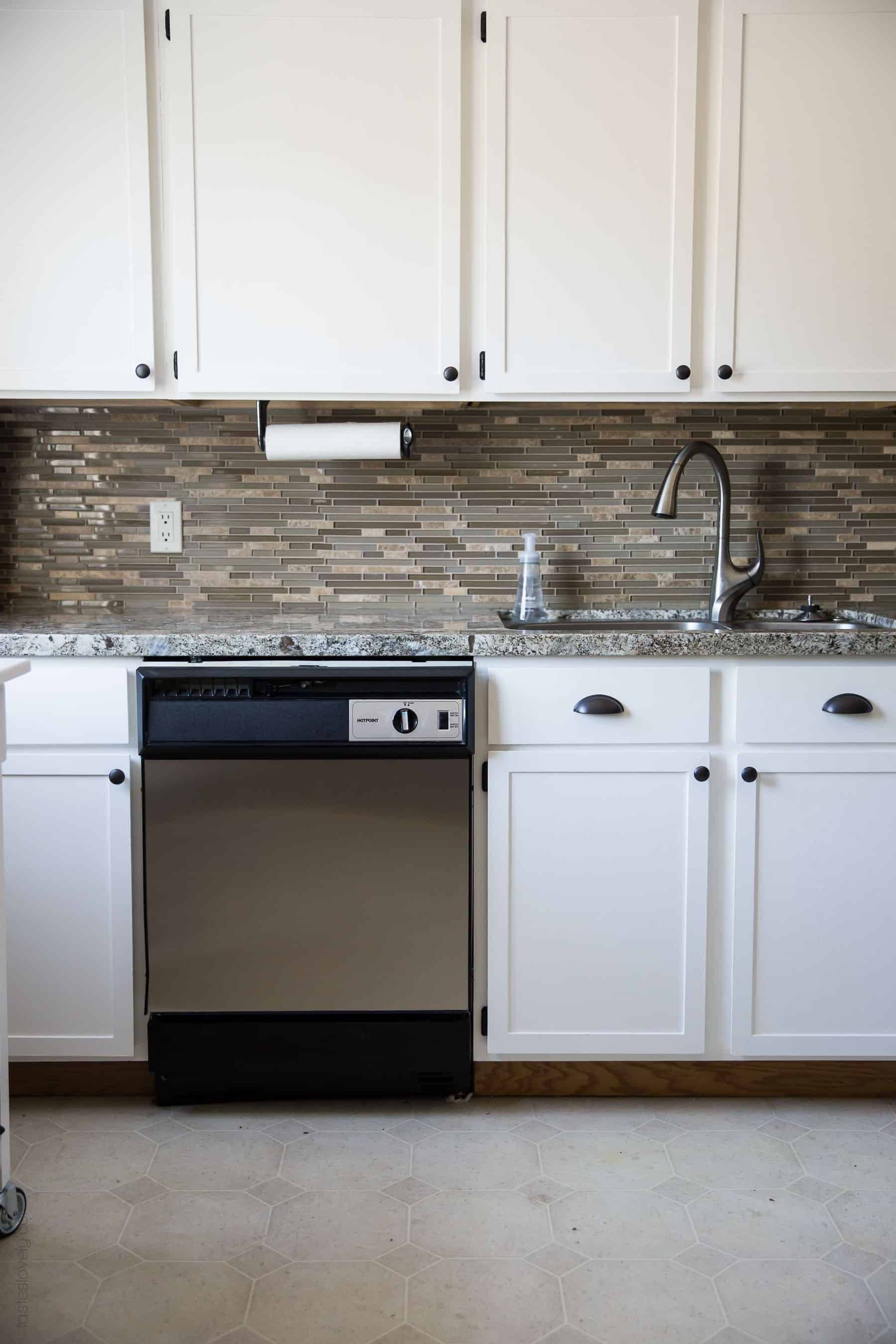 Our $281 DIY Kitchen Remodel - DIY painting oak cabinets white, adding wood trim to make shaker style cabinets, and adding hardware