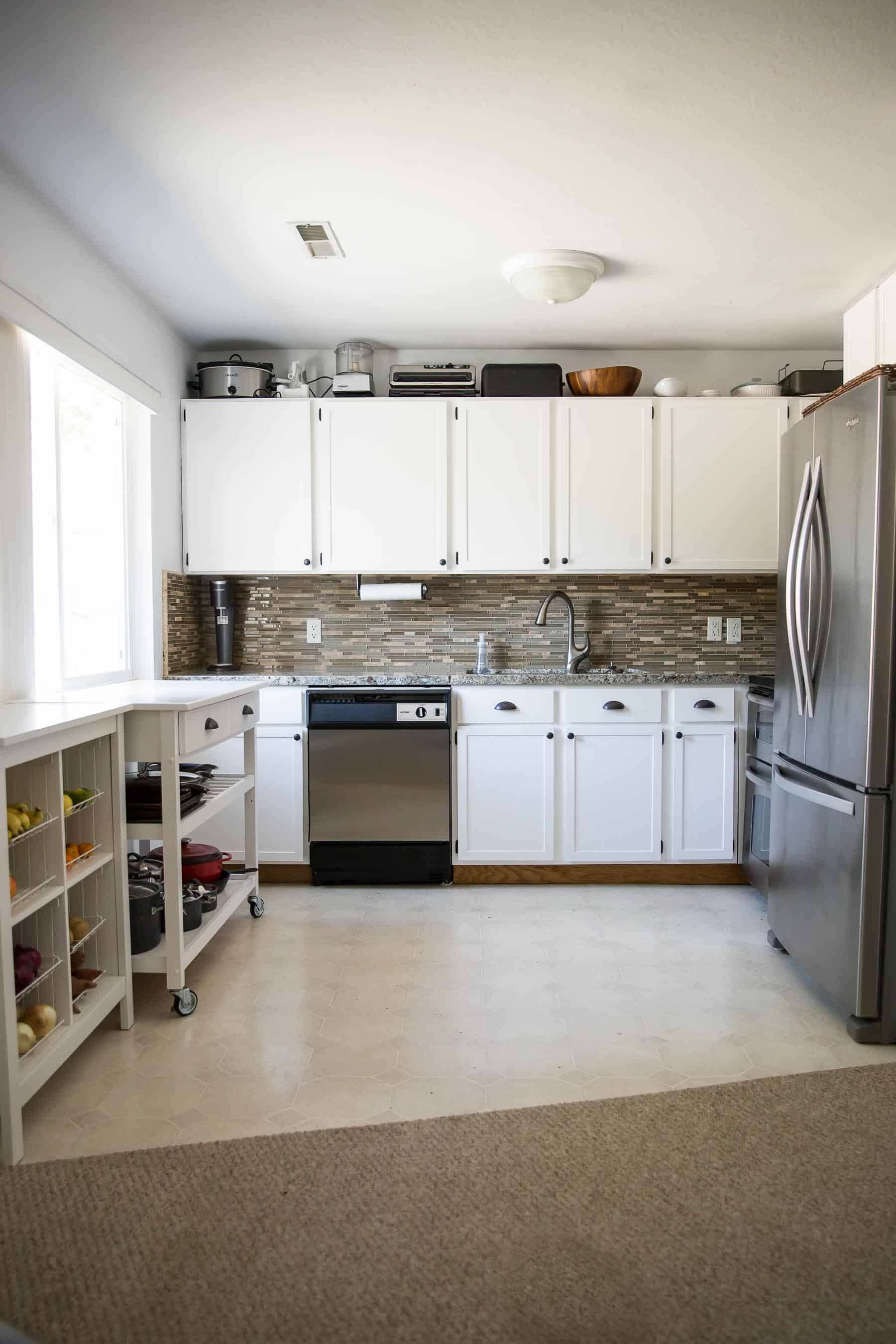 Our $281 DIY Kitchen Remodel - DIY painting oak cabinets white, adding wood trim to make shaker style cabinets, and adding hardware