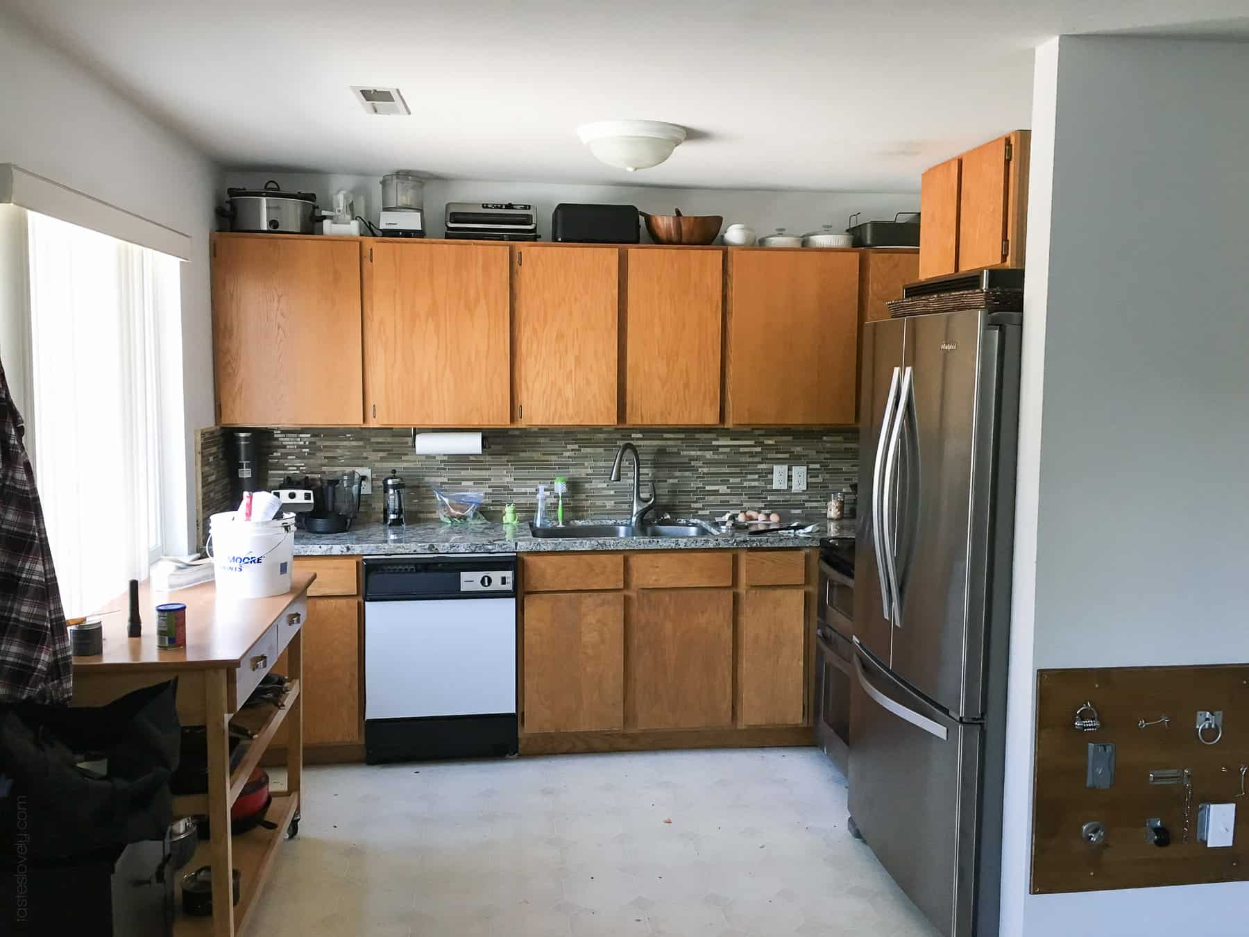 Our $281 DIY Kitchen Remodel - DIY painting oak cabinets white, adding wood trim to make shaker style cabinets, and adding hardware