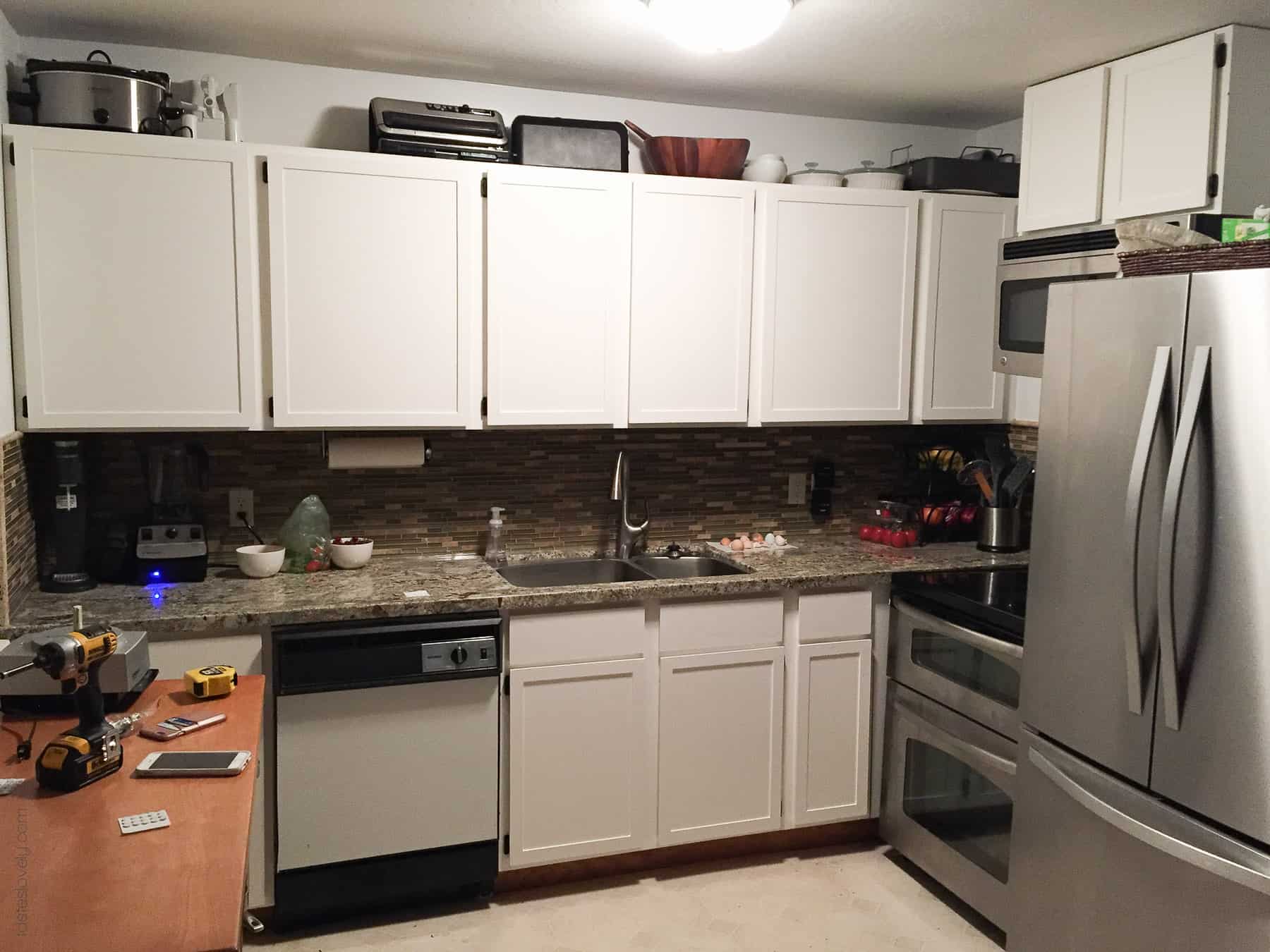 Our $281 DIY Kitchen Remodel - DIY painting oak cabinets white, adding wood trim to make shaker style cabinets, and adding hardware