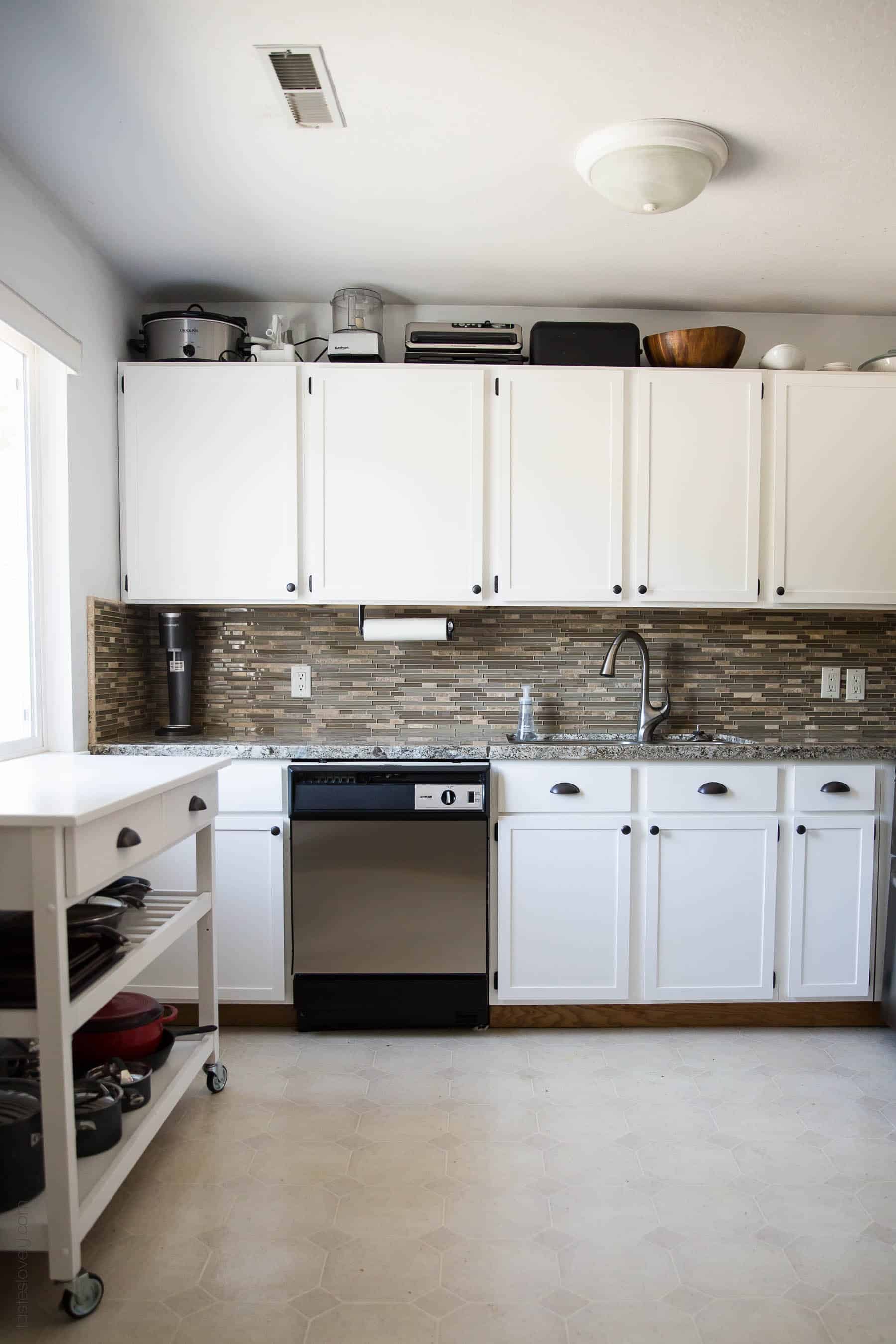 Our $281 DIY Kitchen Remodel - DIY painting oak cabinets white, adding wood trim to make shaker style cabinets, and adding hardware