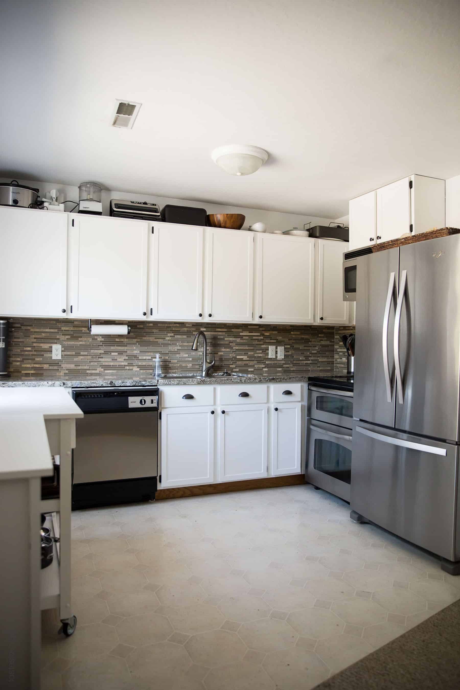 Our $281 DIY Kitchen Remodel - DIY painting oak cabinets white, adding wood trim to make shaker style cabinets, and adding hardware