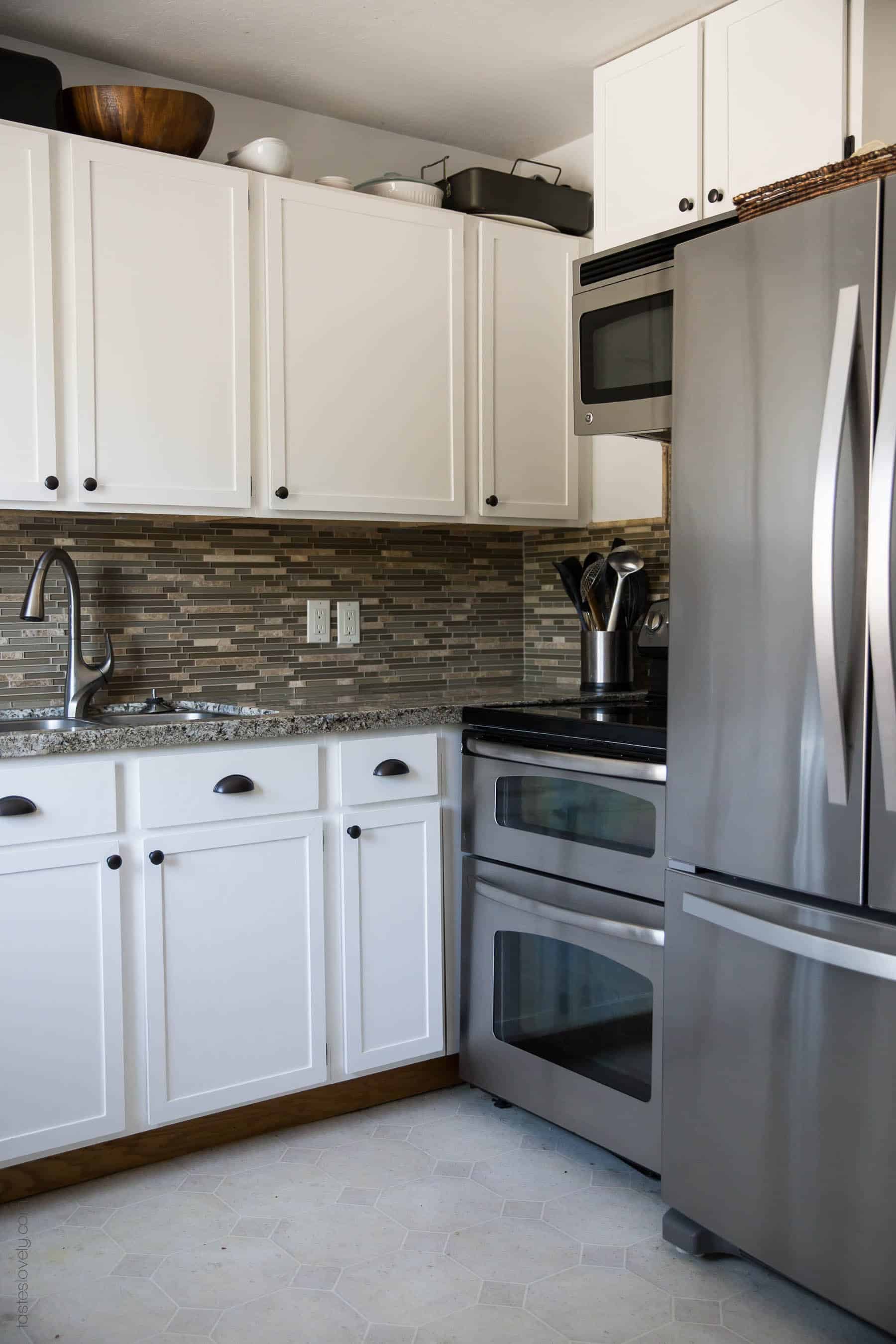 Our $281 DIY Kitchen Remodel - DIY painting oak cabinets white, adding wood trim to make shaker style cabinets, and adding hardware