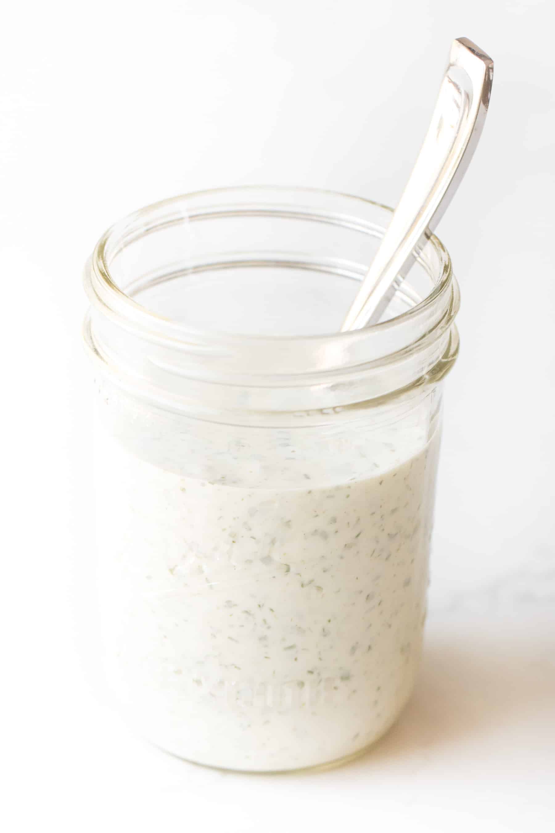 a mason jar with ranch dressing on a white background