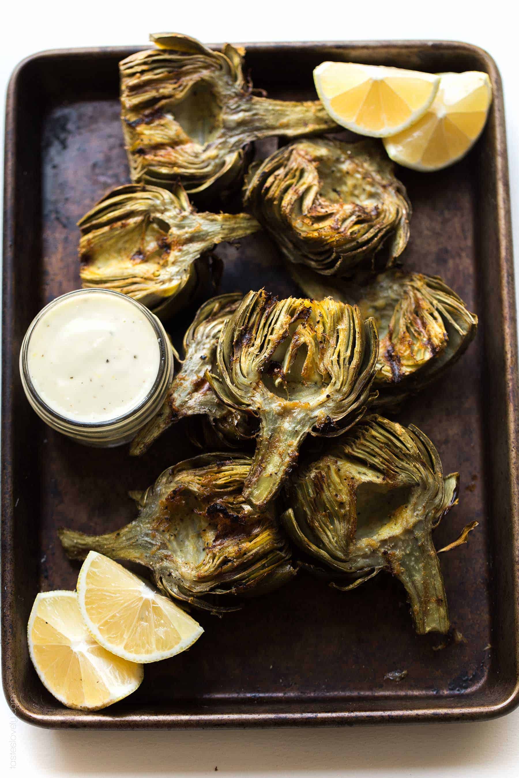 Paleo & Whole30 Grilled Artichokes with a lemon garlic basting oil and a lemon garlic aioli dipping sauce. A delicious appetizer or side dish recipe! Paleo, Whole30, gluten free, grain free, dairy free, sugar free, vegetarian, clean eating.
