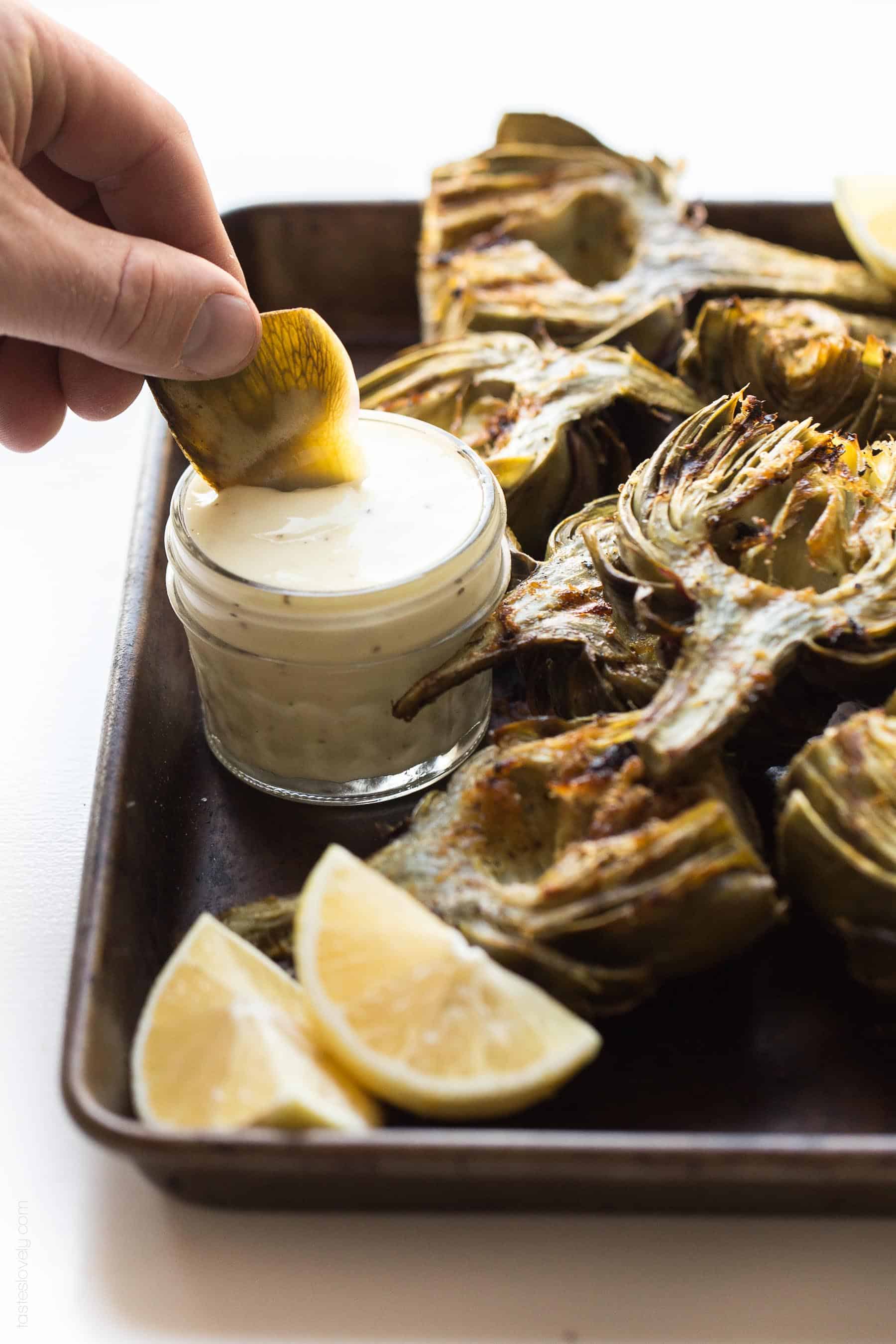 Paleo & Whole30 Grilled Artichokes with a lemon garlic basting oil and a lemon garlic aioli dipping sauce. A delicious appetizer or side dish recipe! Paleo, Whole30, gluten free, grain free, dairy free, sugar free, vegetarian, clean eating.