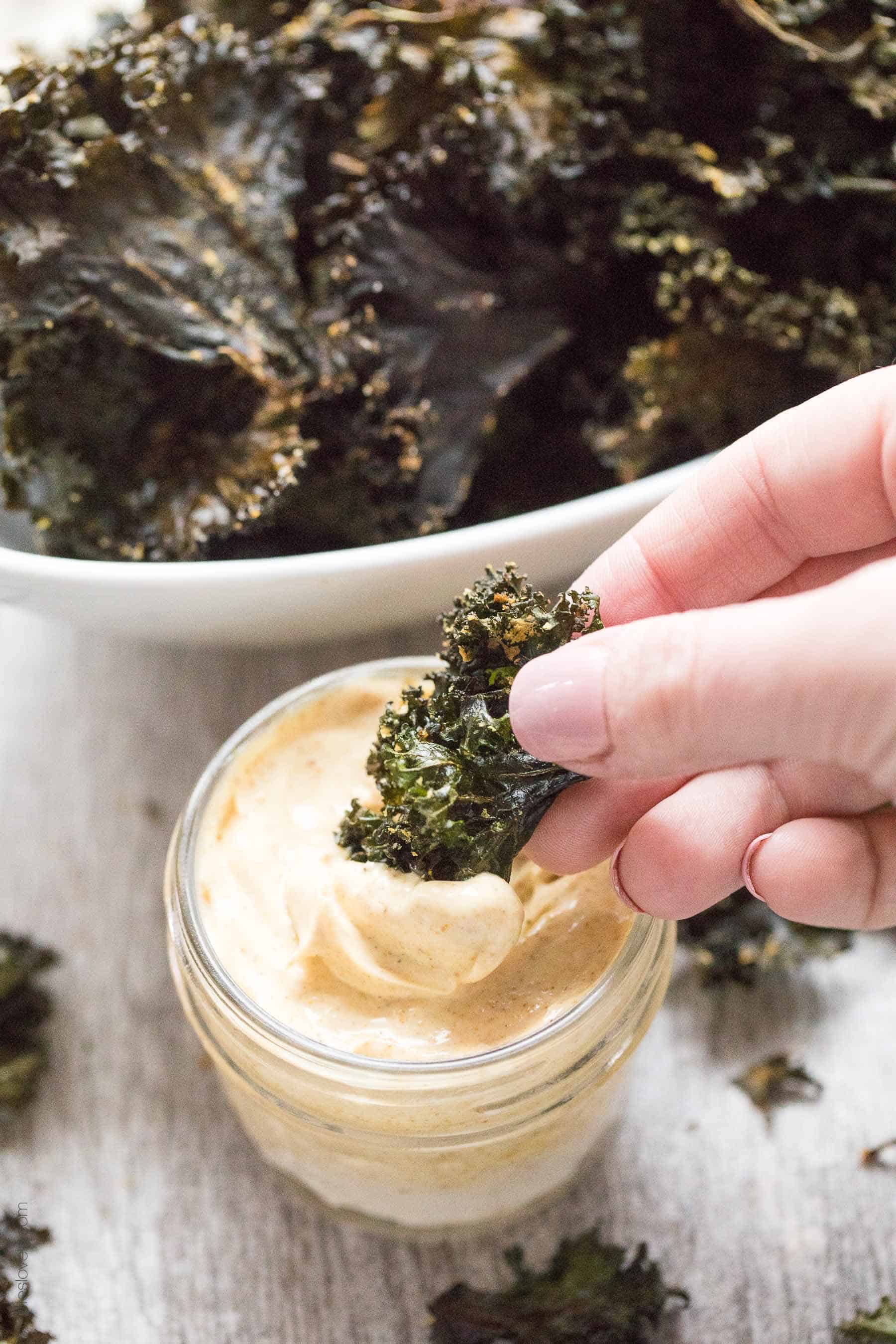 Roasted Kale Chips with Curry Aioli - a crispy, crunchy salty snack that is Paleo & Whole30. Ready in 20 minutes. Served with a curry aioli dipping sauce.
