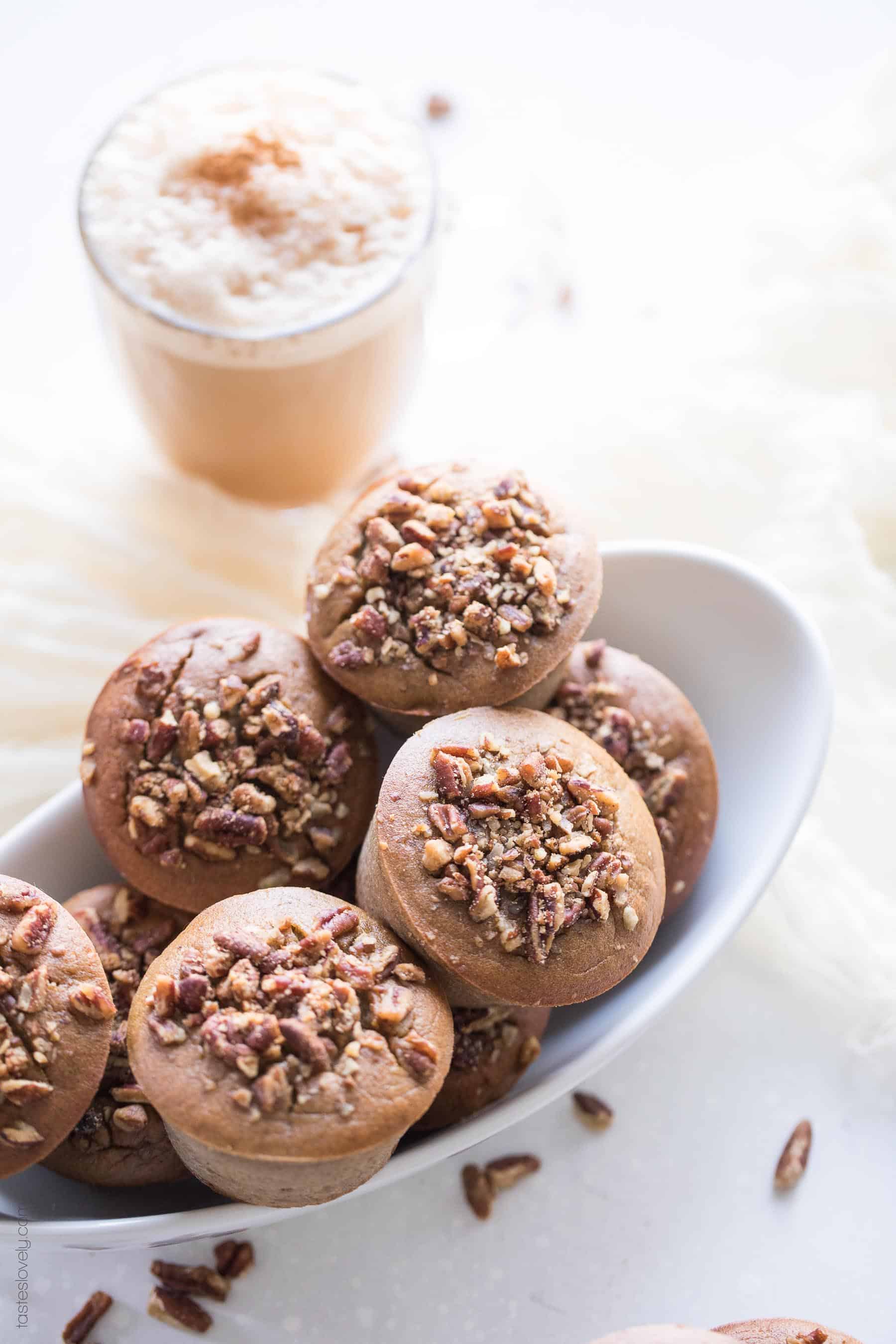 Paleo chai spice muffins in a bowl with a chai latte in the background