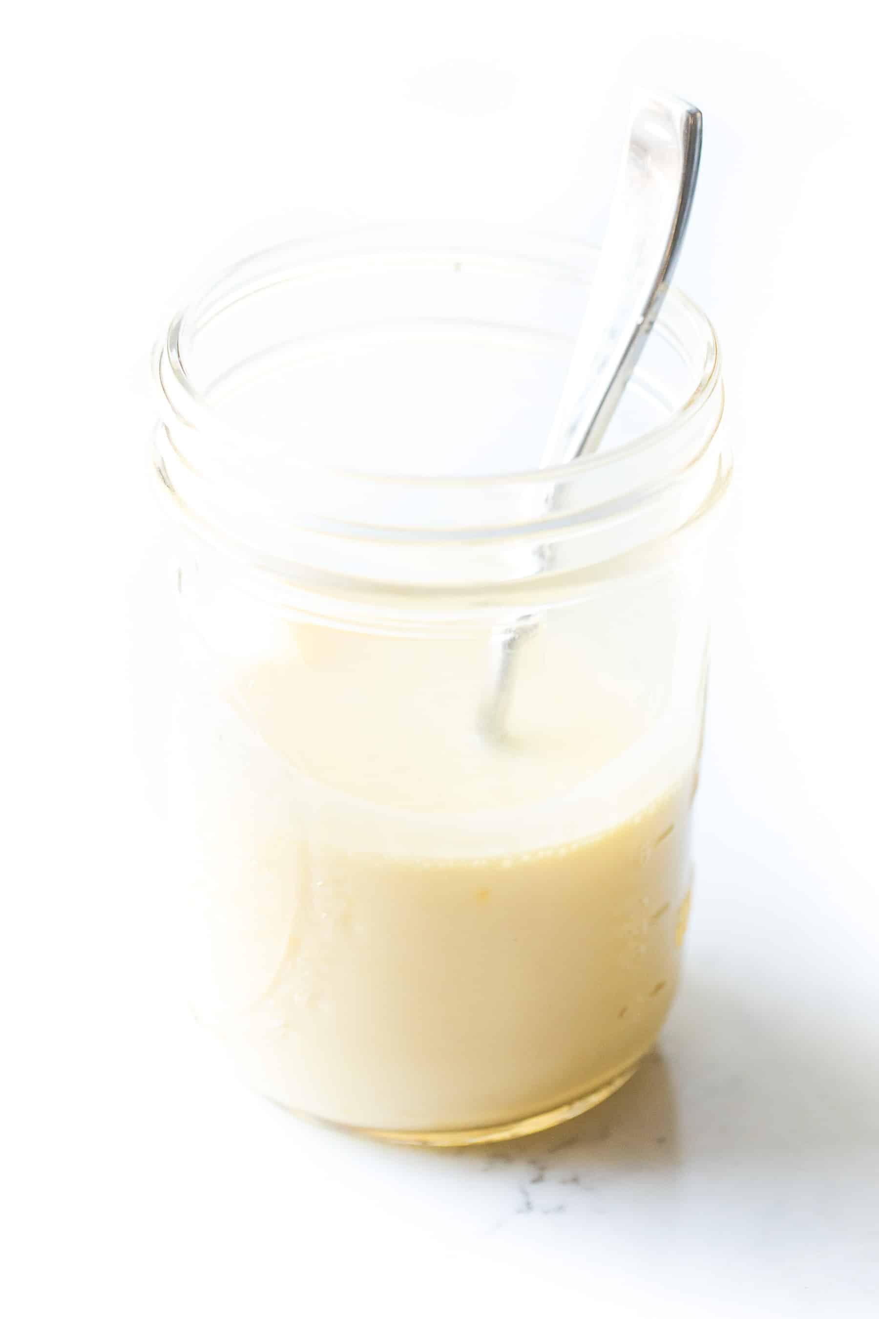 Hollandaise sauce in a mason jar with a spoon