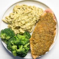 chicken on a plate next to vegetables.