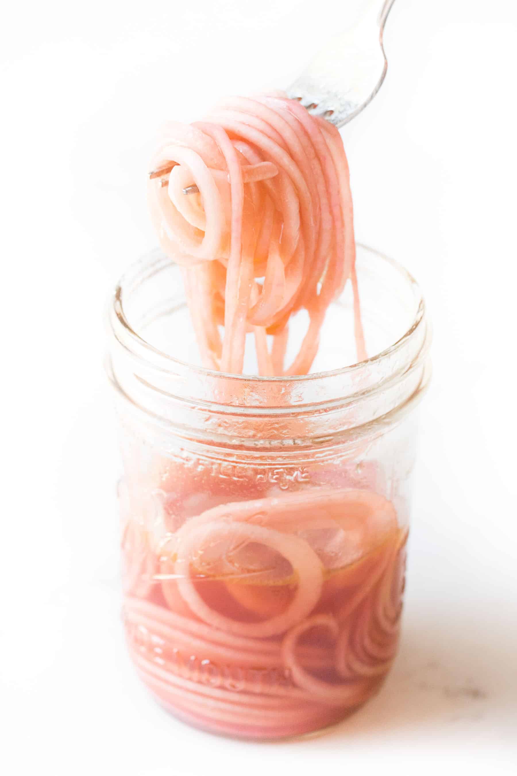 pickled onions in a mason jar on a white background