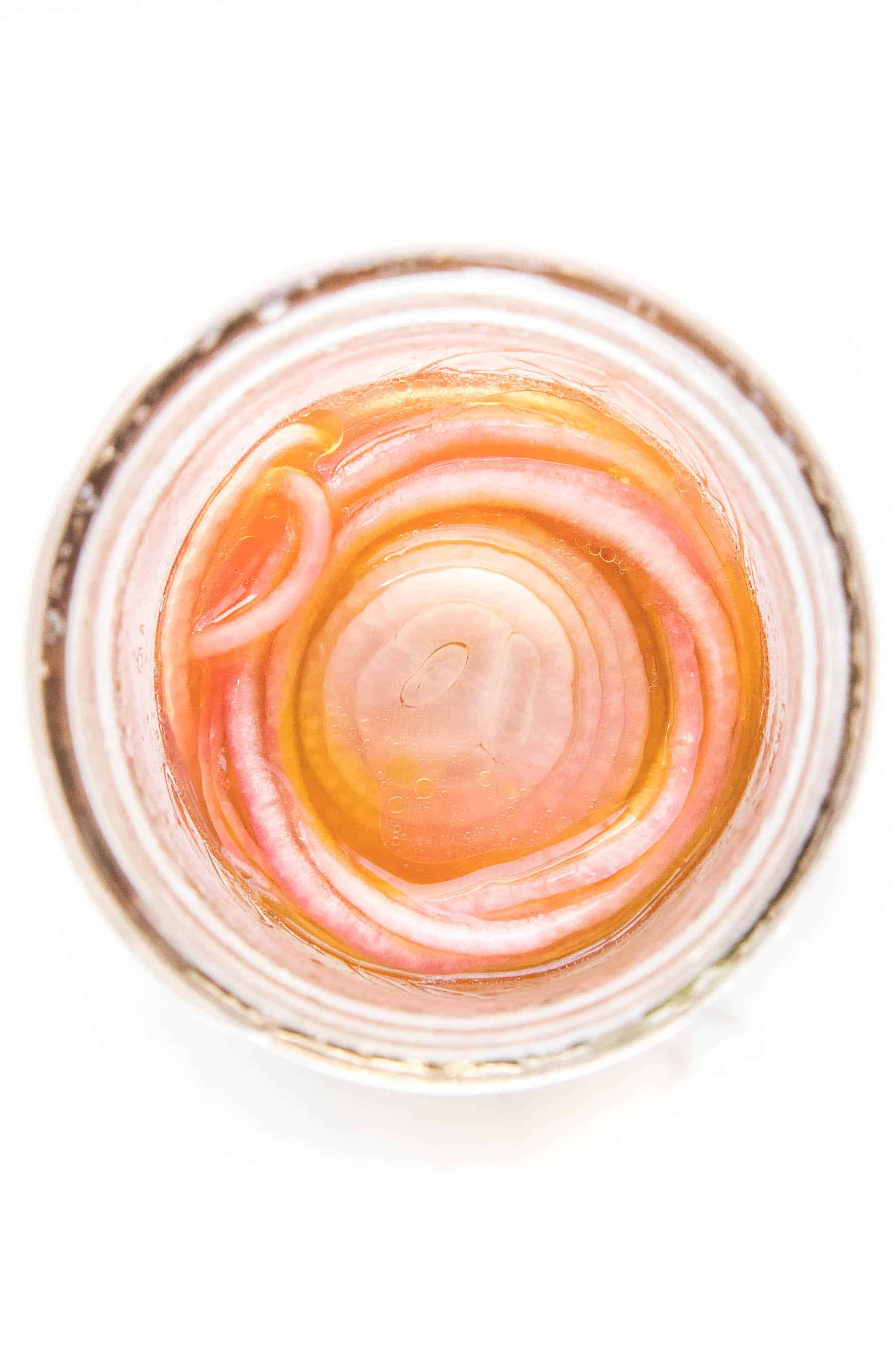 pickled onions in a mason jar on a white background