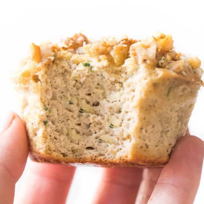 hand holding a paleo zucchini muffin on a white background