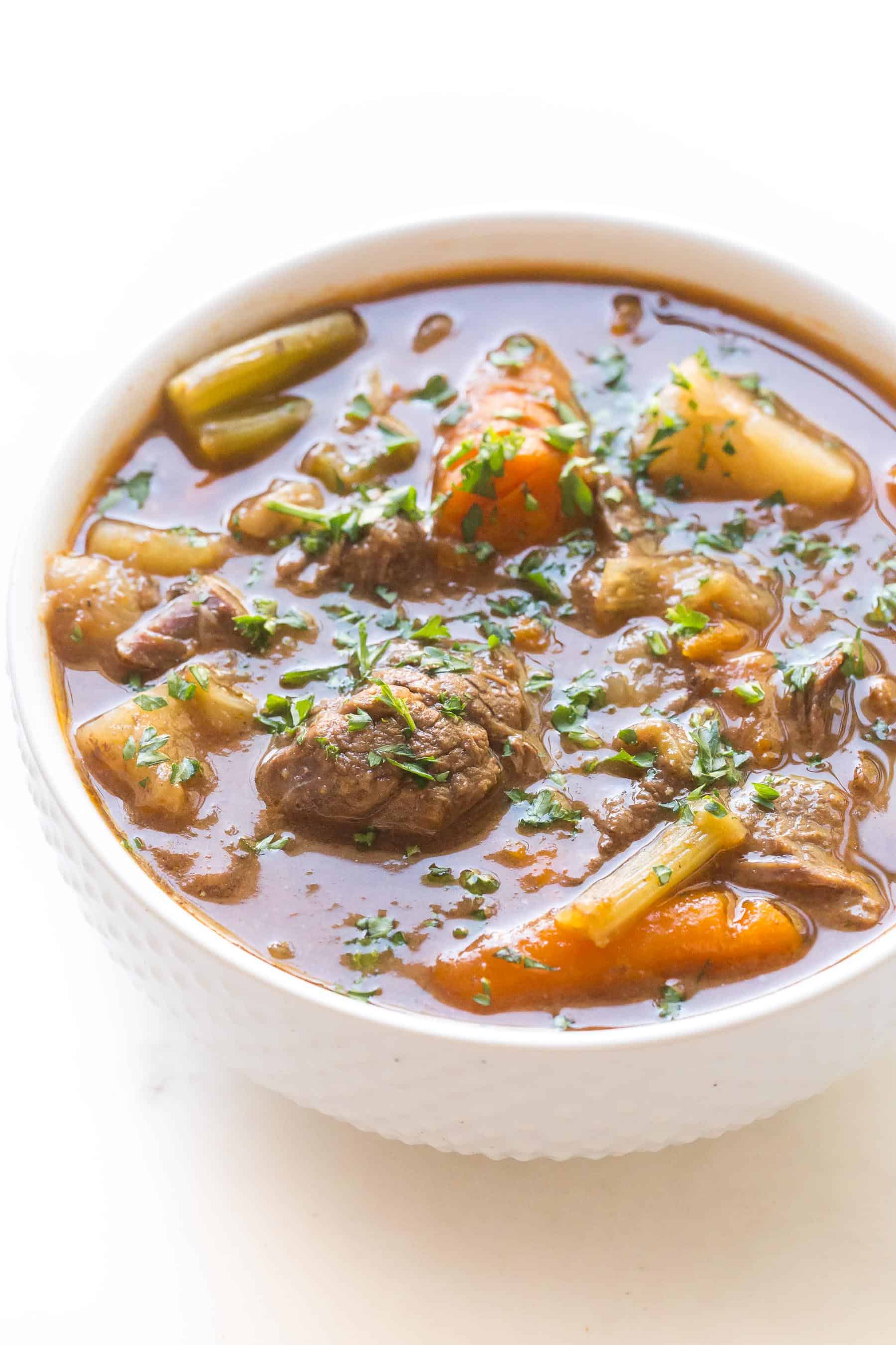 beef stew in a white bowl on a white background