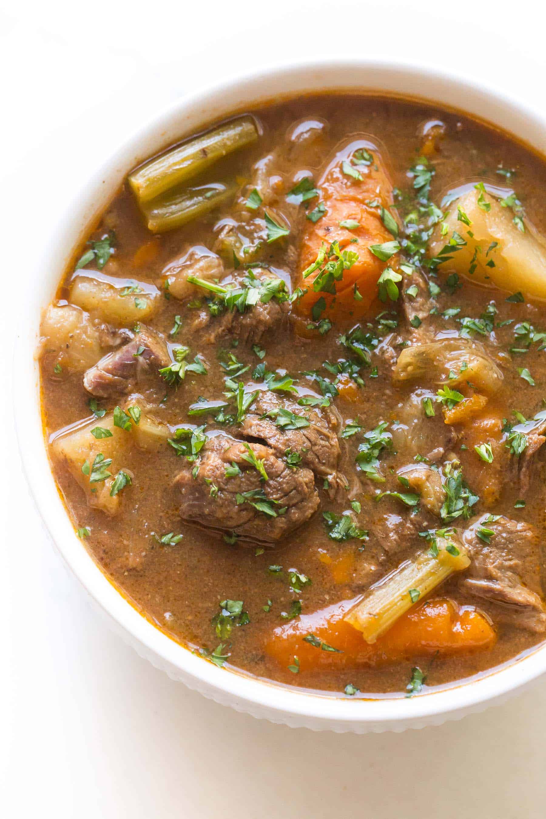 beef stew in a white bowl on a white background