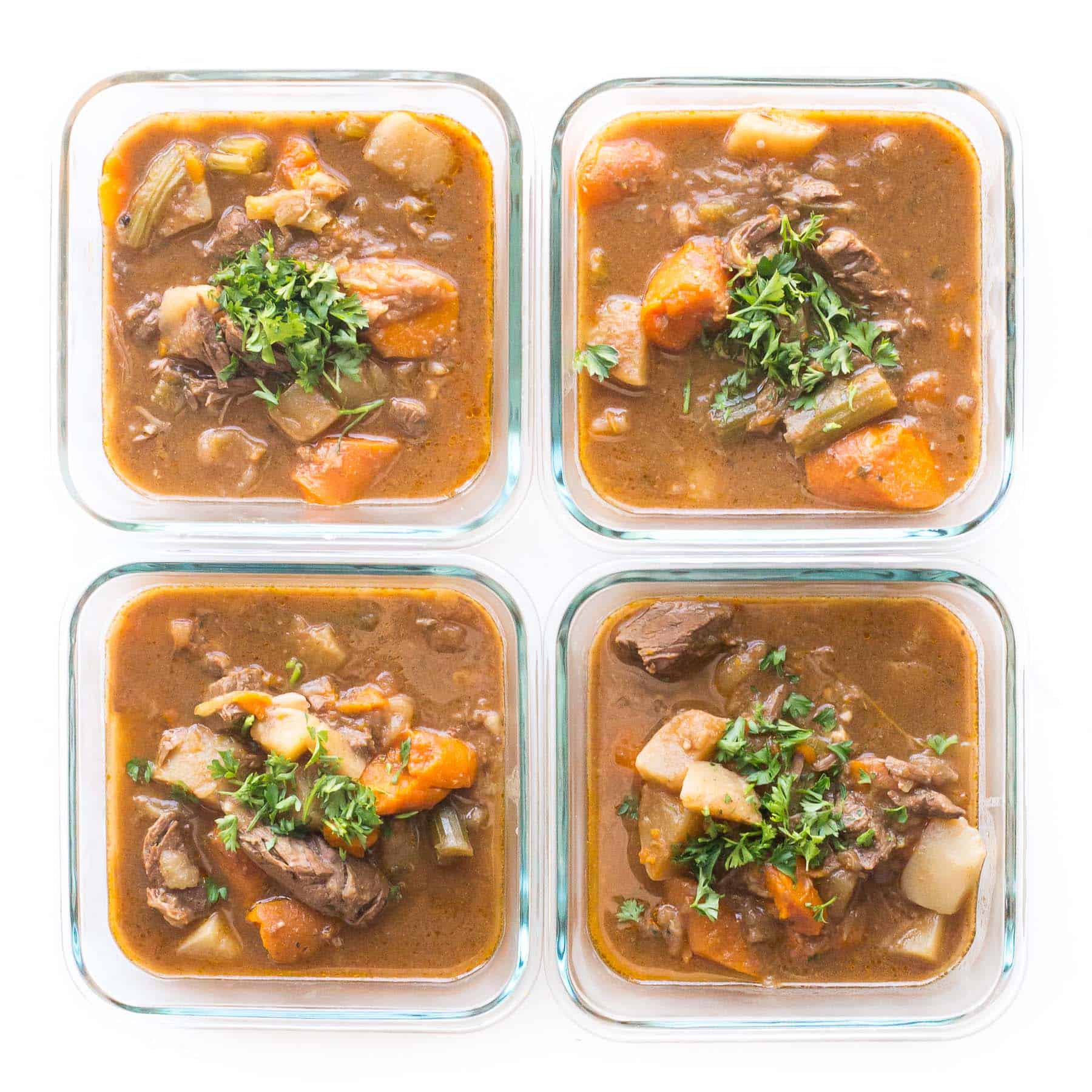 meal prep beef stew in meal prep containers l on a white background