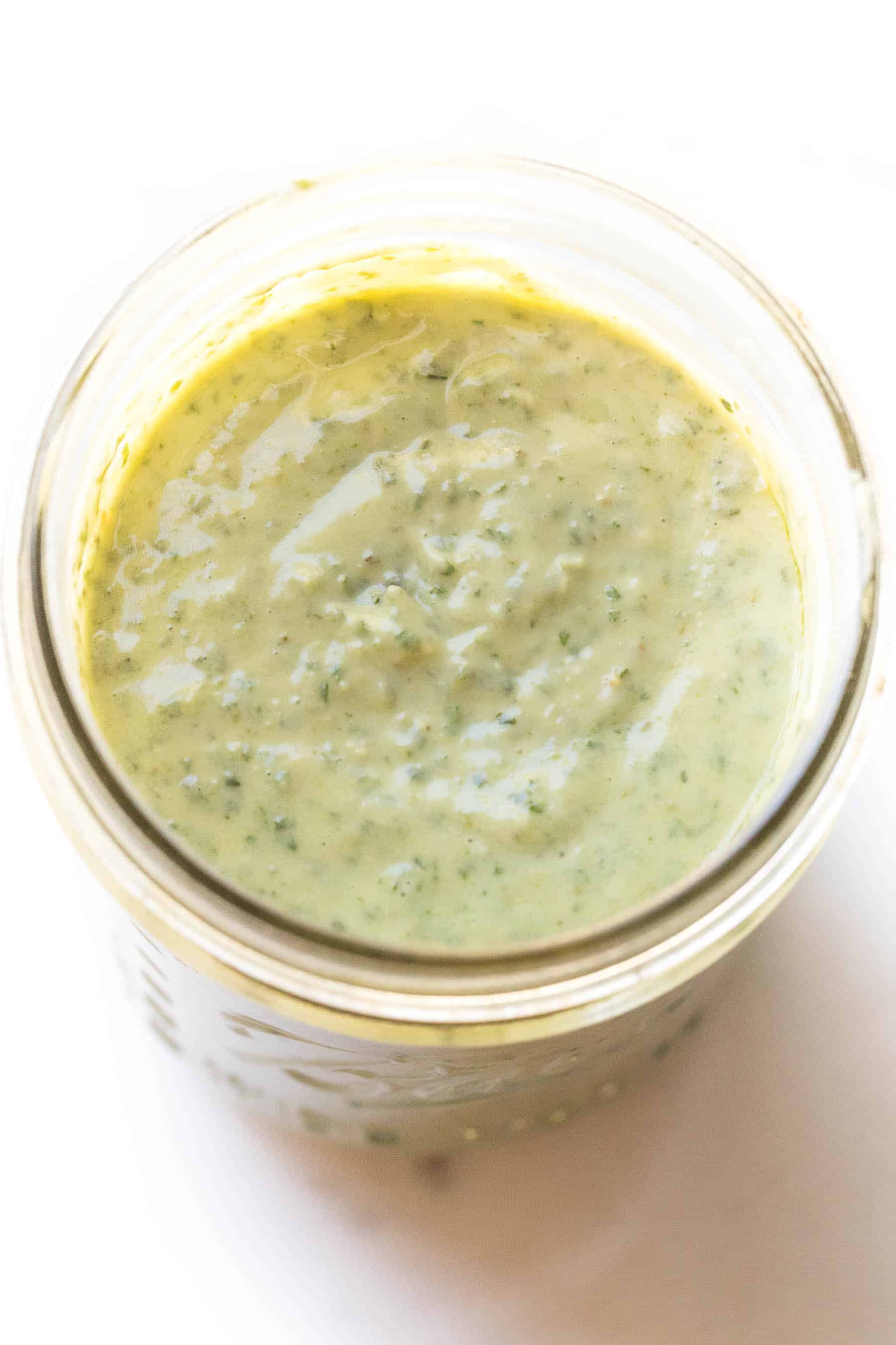 pesto aioli in a mason jar on a white background