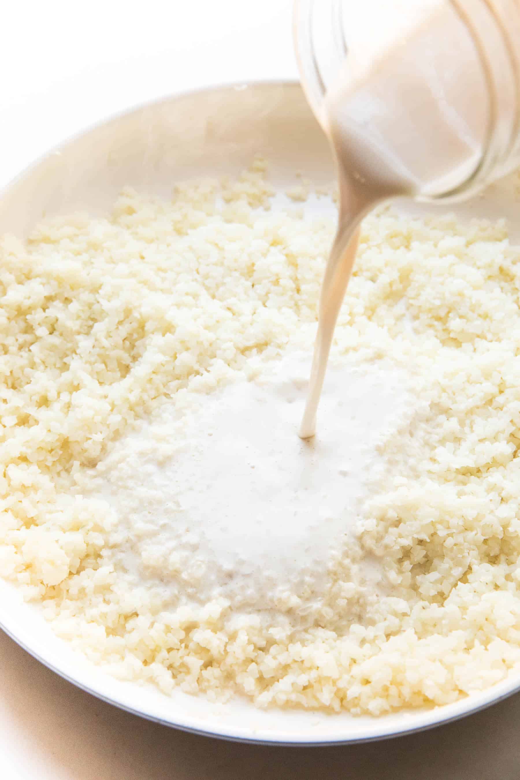 steps to making cauliflower rice risotto, pouring in creamy liquid to cauliflower rice