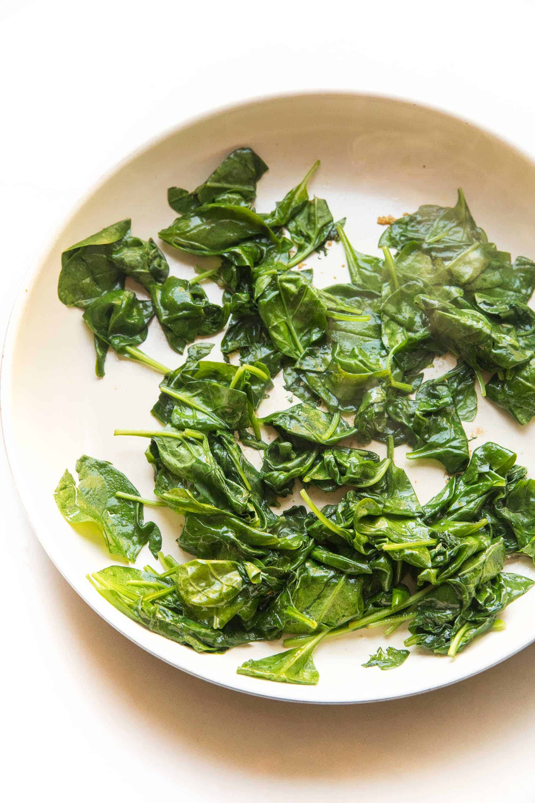 sauteed spinach in a white skillet