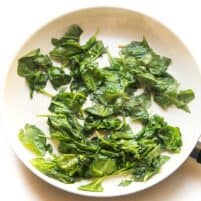 sauteed spinach in a white skillet