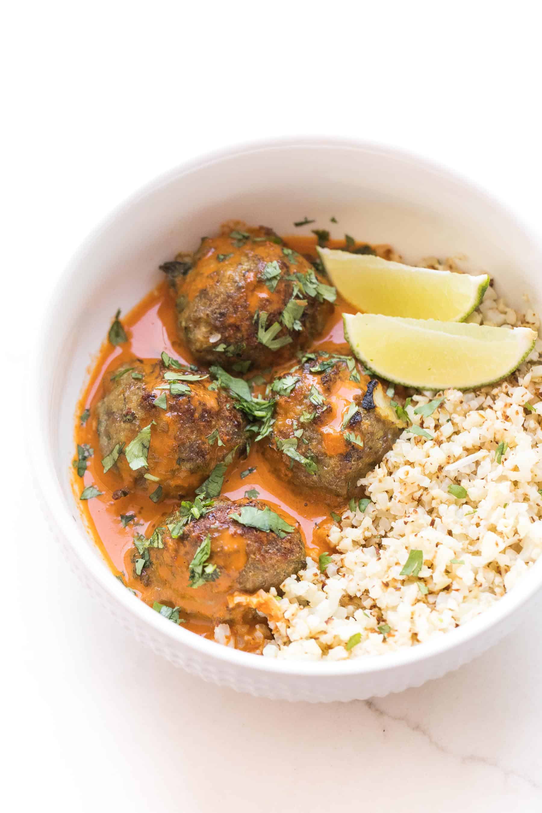 thai curry meatballs in a white bowl with thai curry sauce